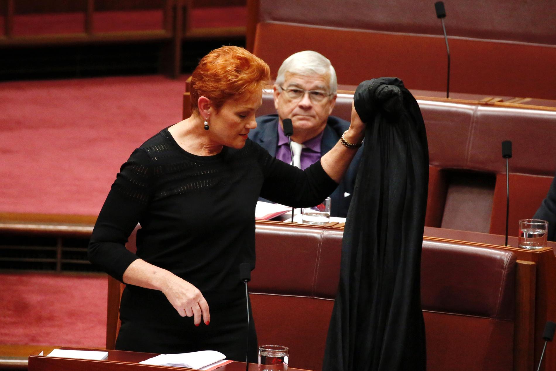 Senator Pauline Hanson, ledare för det invandringsfientliga partiet One Nation, har varit i blåsväder tidigare. 2017 klädde hon sig i burka i senatens kammare i Canberra i ett försök att förbjuda klädesplagget. I bakgrunden senator Brian Burston. Arkivbild.