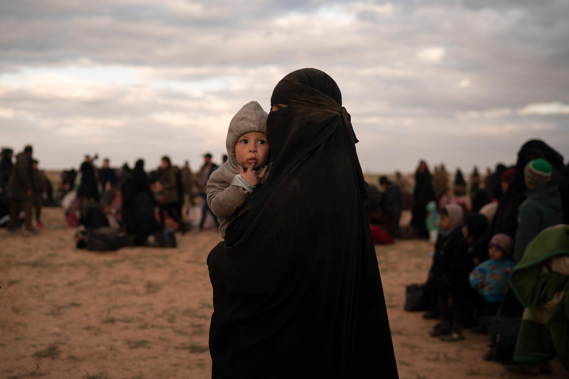 En kvinna med ett barn som evakuerats från ett område i östra Syrien som kontrolleras av terrorgruppen IS.