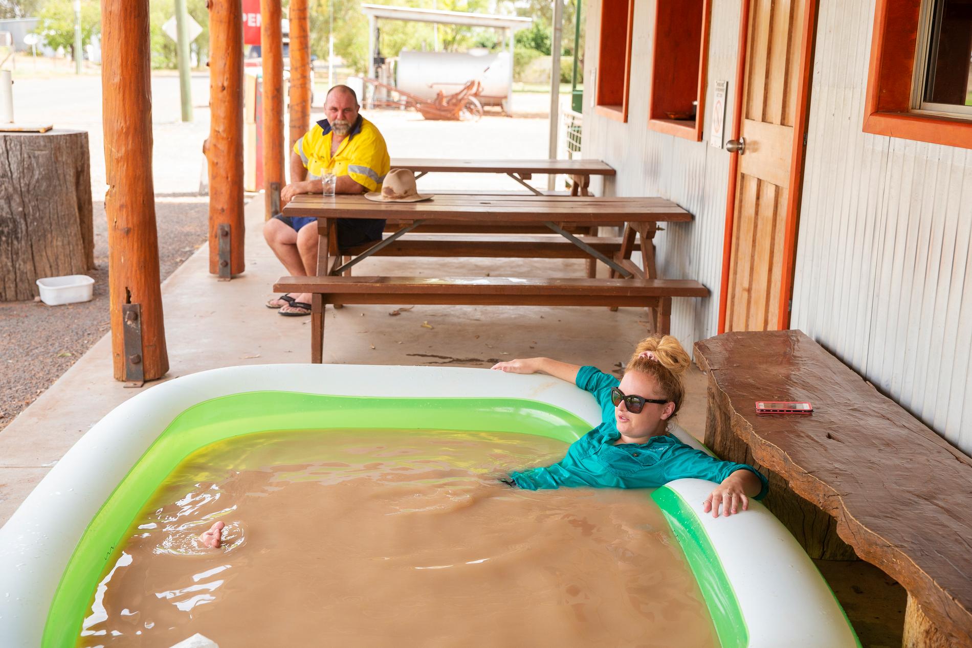 Jasmin Kew svalkar sig i en uppblåsbar pool med missfärgat kranvatten i den 47 gradiga hettan. 