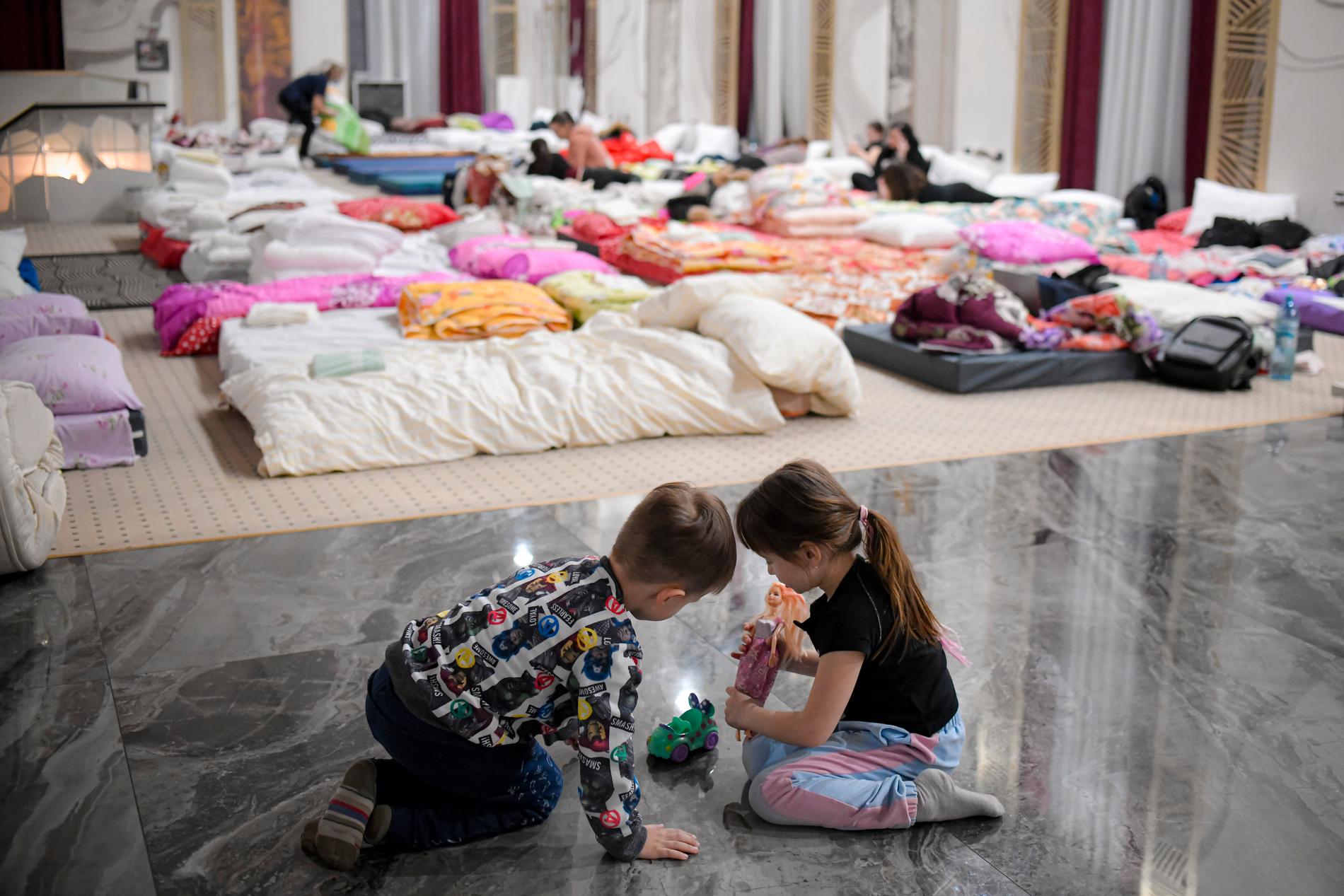 Barn som flytt från Ukraina leker på golvet i ett hotell som erbjuder skydd för flyktingar i Siret, Rumänien på lördagen.