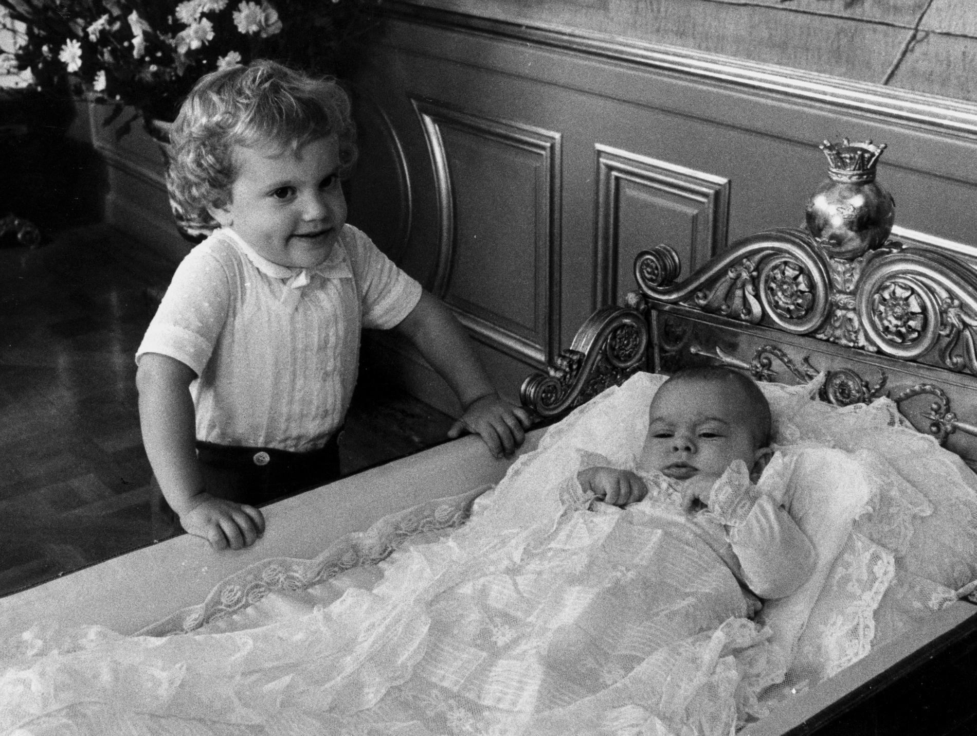 Prins Carl Philip, 3 år, kollar in lillasyster Madeleine i dopklänning. Samma dopklänning som burits av alla kungabarnen och barnbarnen kommer även bäras av den nyaste medlemmen i kungafamiljen, prinsessan Adrienne som döps i juni. Arkivbil.