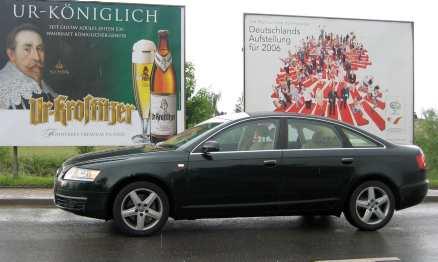Oss tyska kändisar emellan. Kung Gustav II Adolf blickar ned från sin reklamskylt och beskådar en vägkejsare – Audi A6.