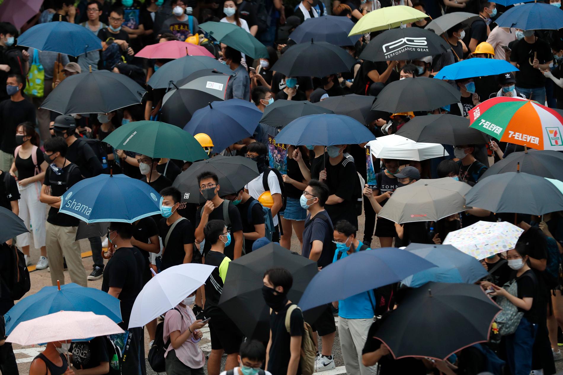 Demonstranter under paraplyer samlas på en motorväg i Hongkong.