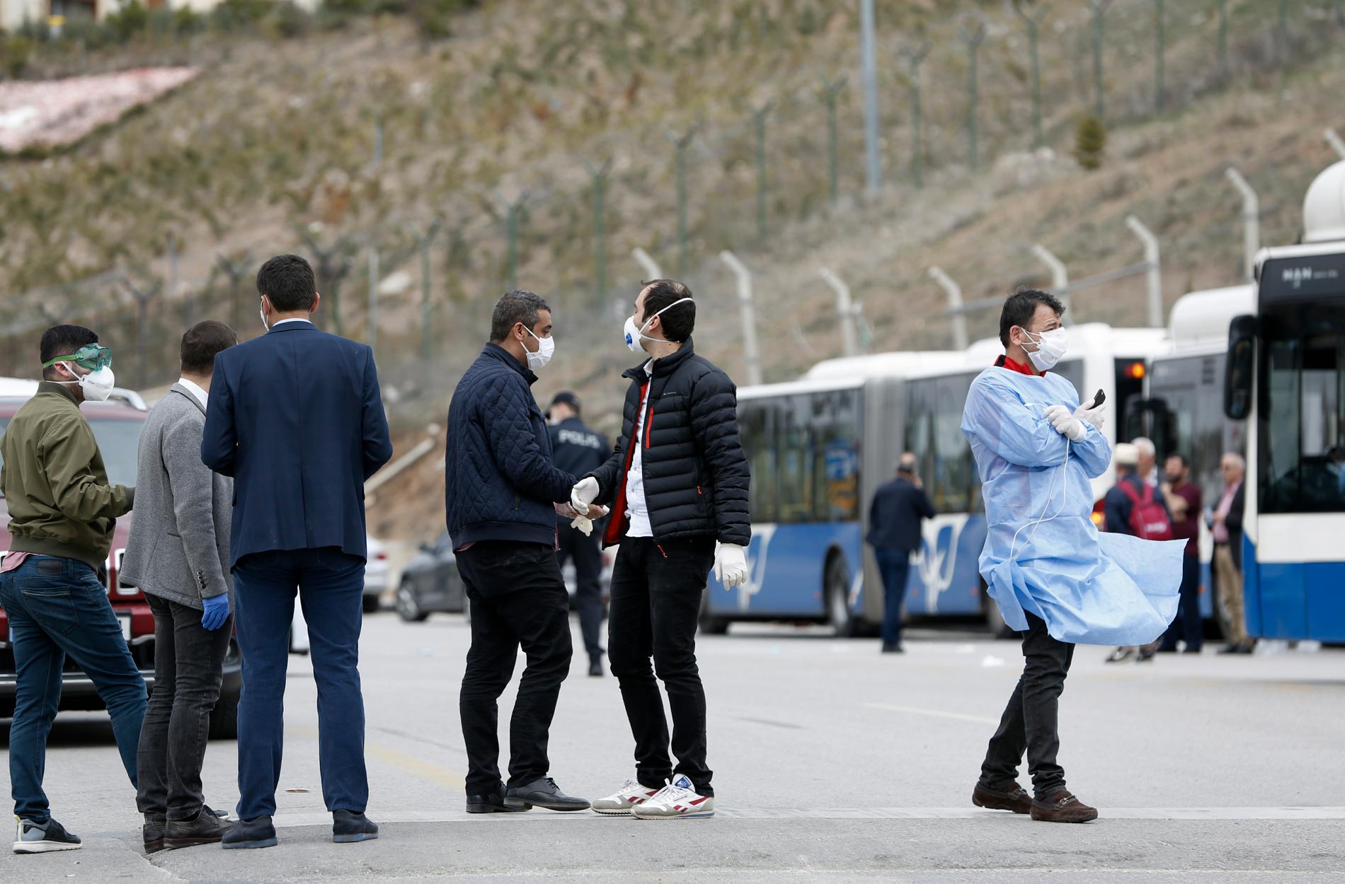 Hälsoarbetare i Turkiet utanför en buss som fraktar resenärer till ett boende på ett universitet där de ska hållas i karantän med anledning av coronaviruset. Resenärerna i fråga har just återvänt från en pilgrimsresa till Saudiarabien.