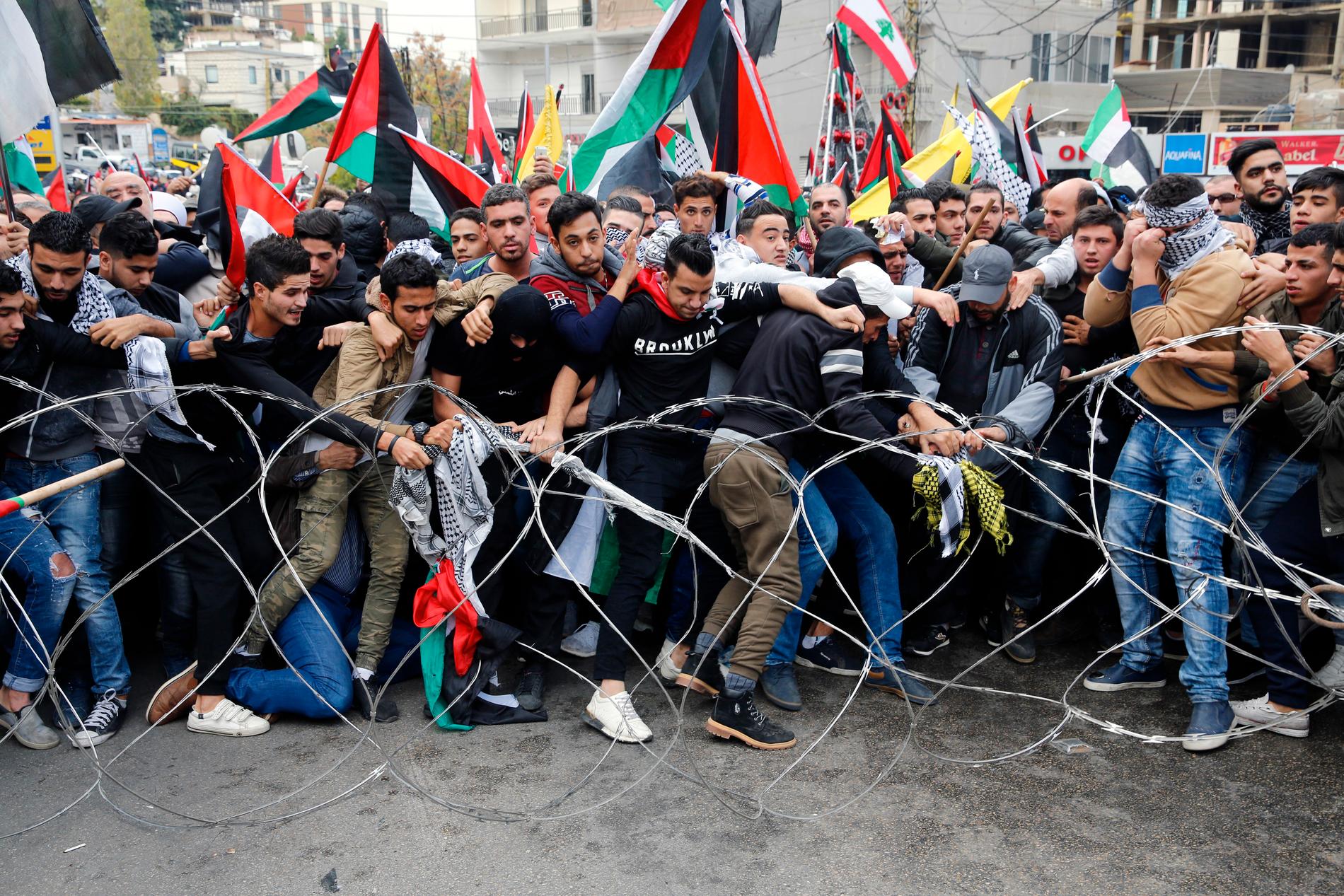 Demonstranter försöka slita loss taggtråd som blockerar vägen till USA:s ambassad. 