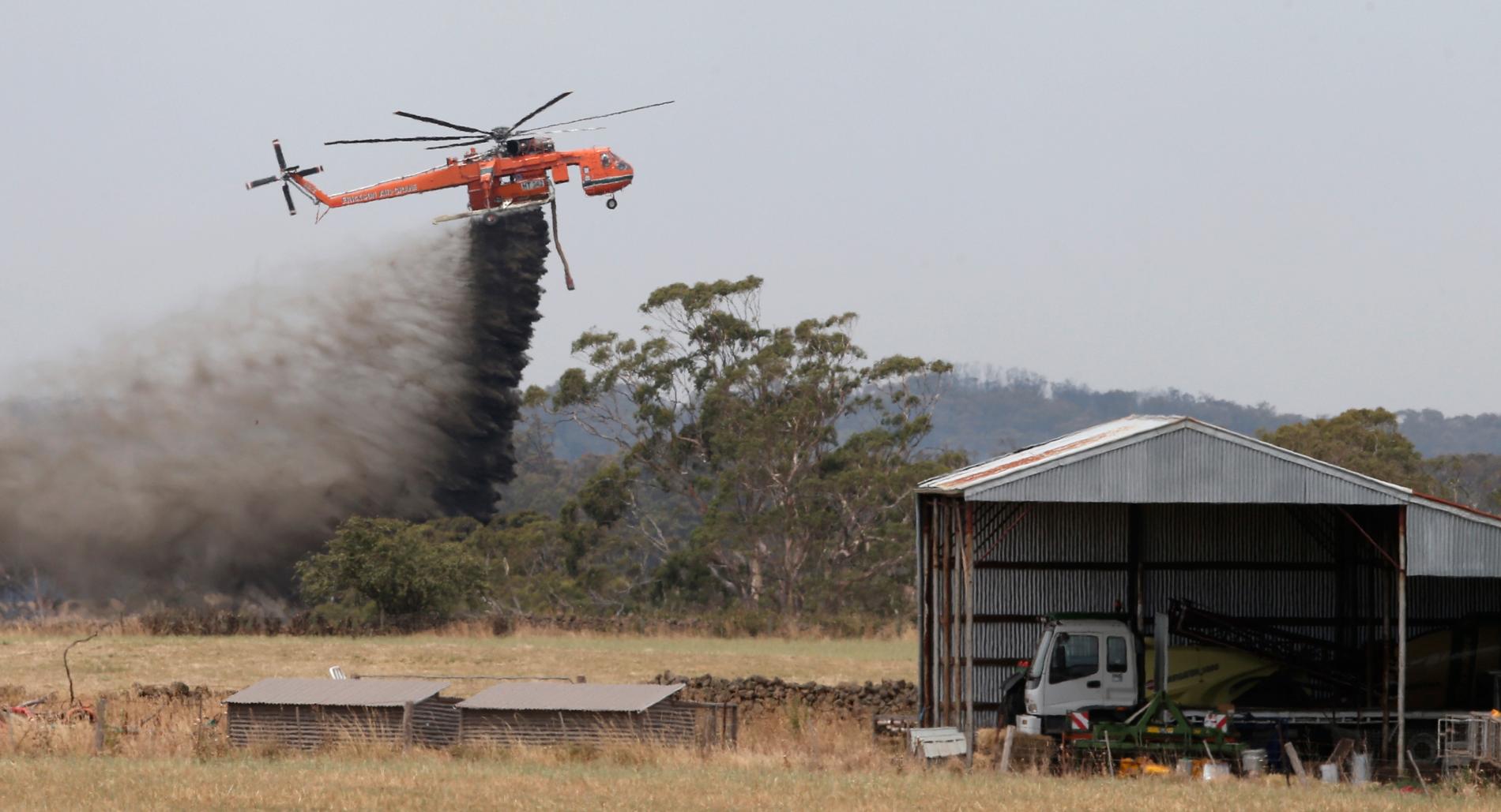 En Skycrane-helikopter vattenbombar ett skogsområde som ett försök att stoppa en skogsbrand från att sprida sig i Claredon i Australien.