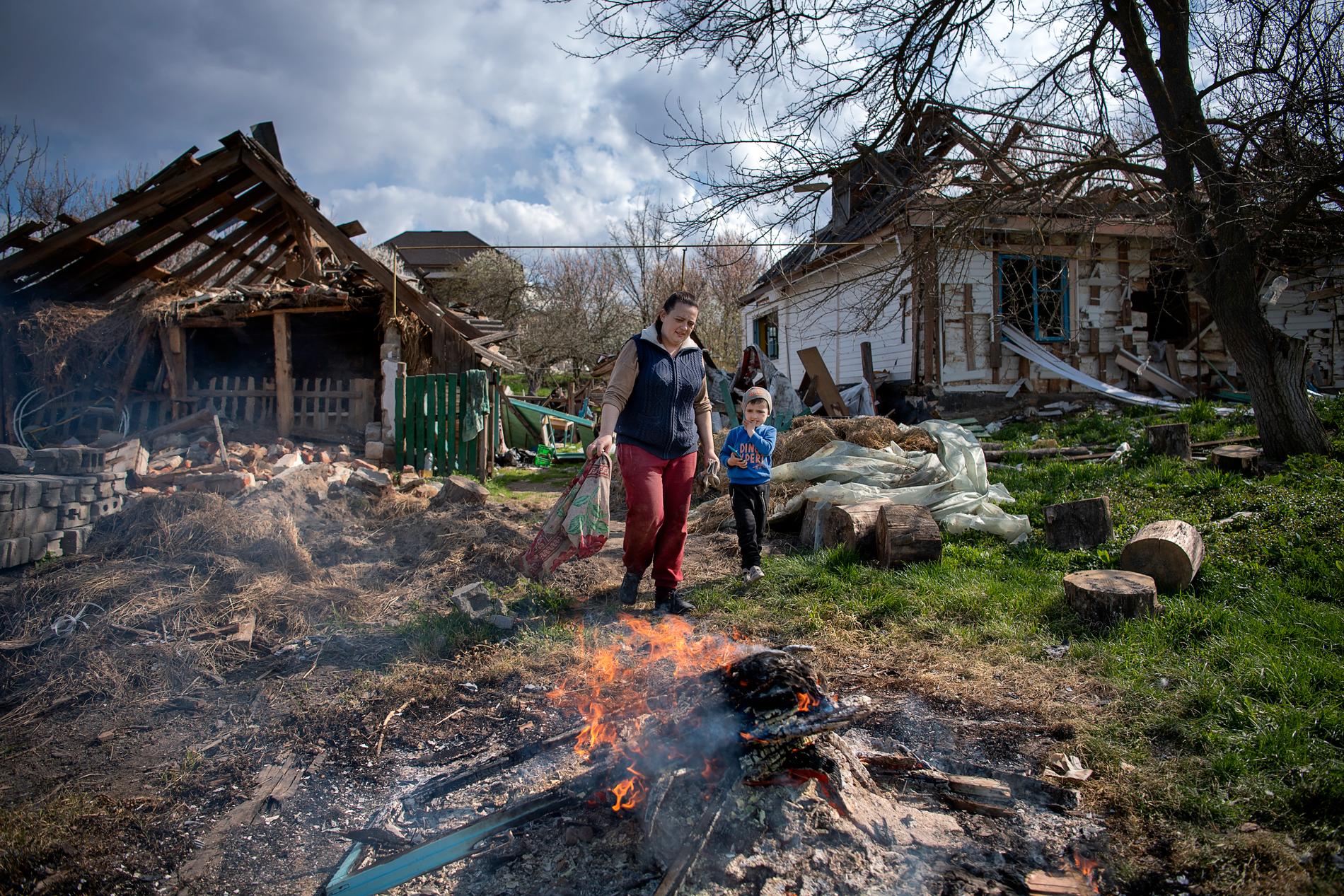 Anya och Volodymyr på gården där de bränner upp ryska lämningar och saker i huset som de inte kunnat identifiera.