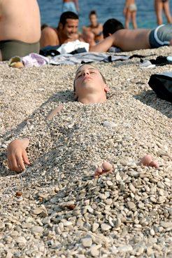 Lena stenar täcker stranden Zlatni Rat på Braç "