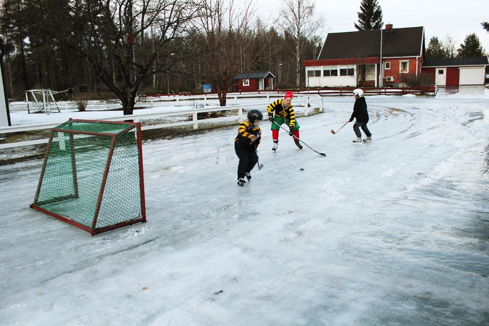 Jesper, Oskar och Ida Karlsson spelar ishockey på gatan i Skellefteå.
