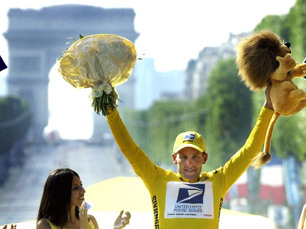 Höjer armarna i skyn med Champs-Élysées som bakgrund efter Tour-segern 2001.