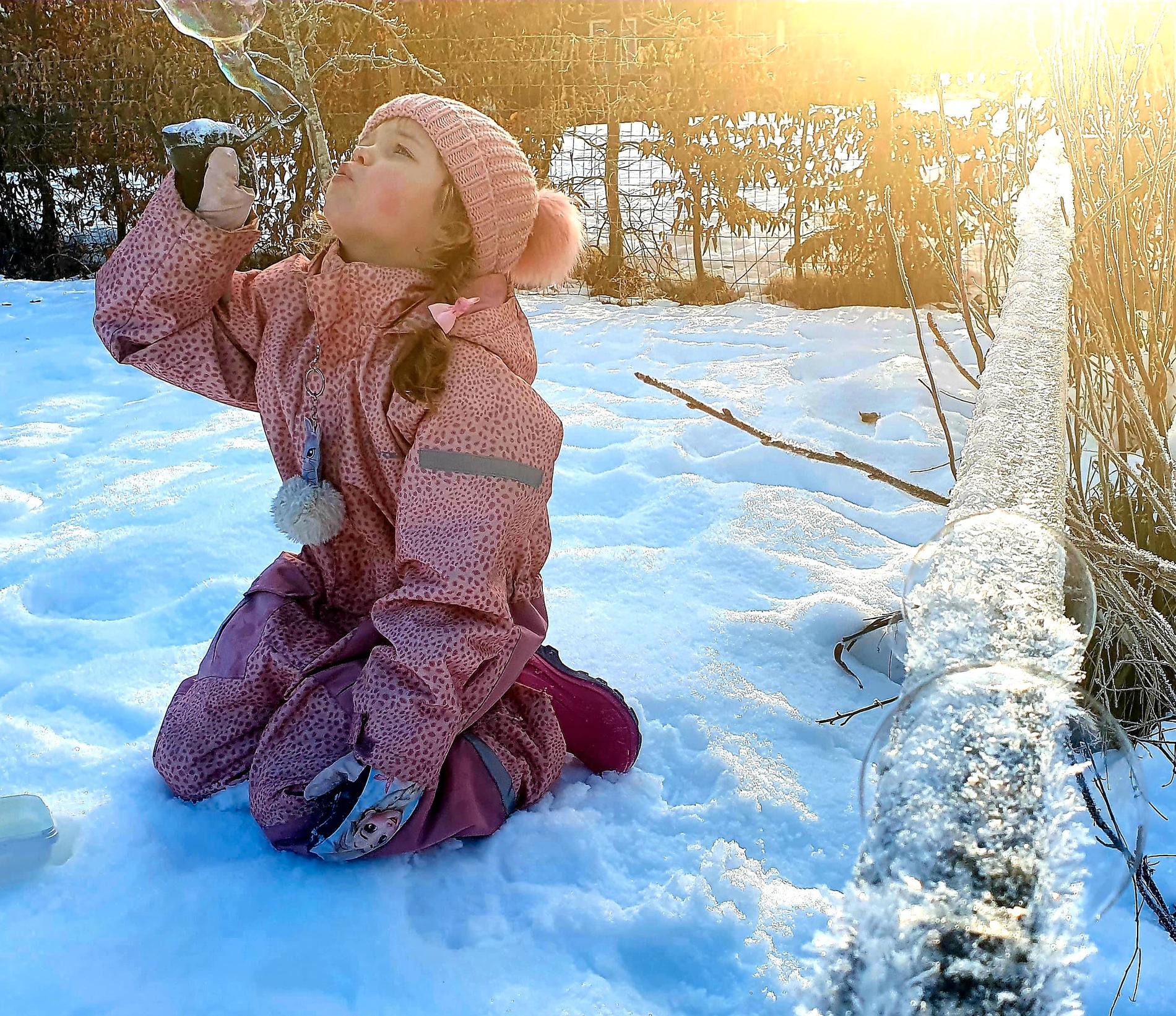 Storasyster Vanessa, 6, visar hur man ska blåsa vinter-såpbubblor.