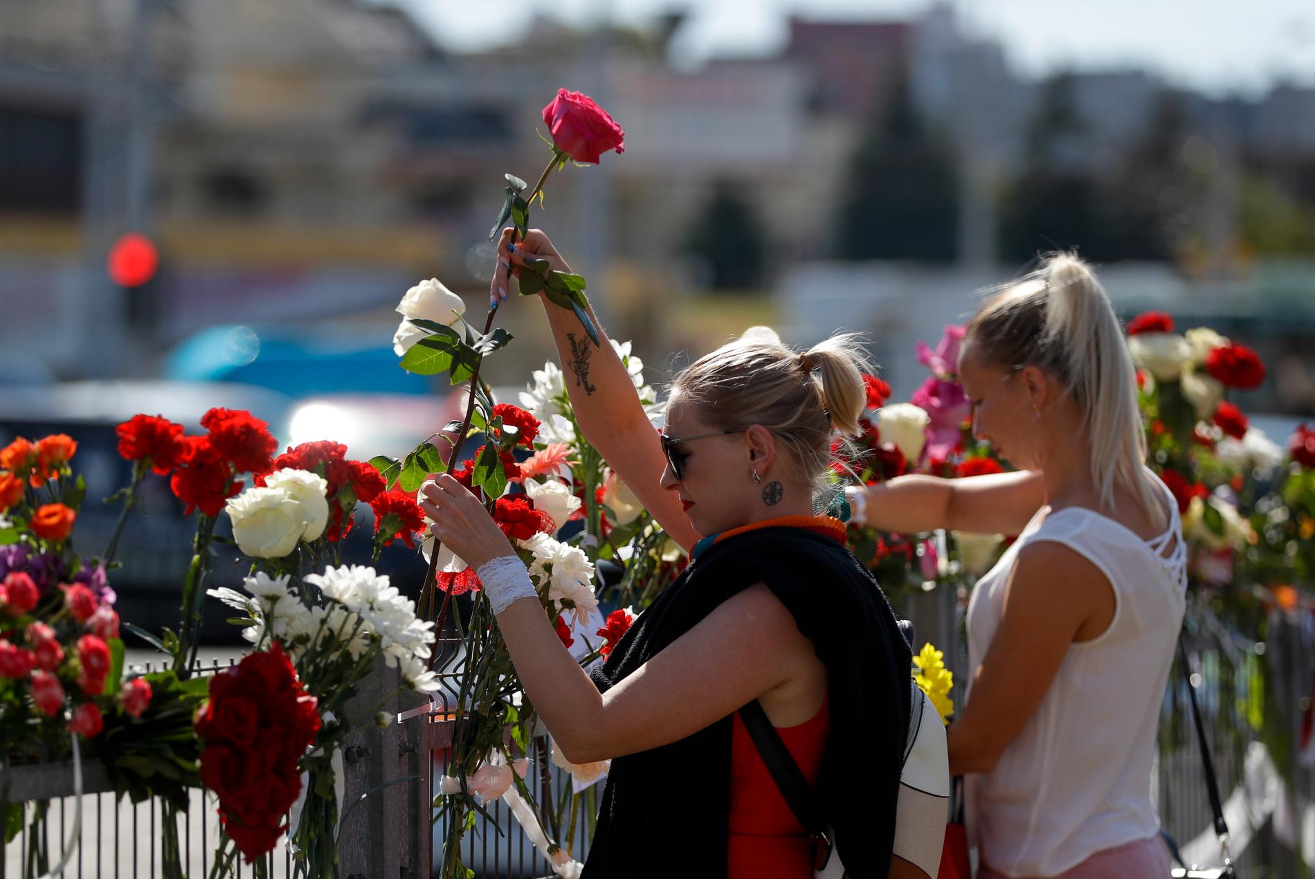 Minskbor lägger ned blommor på platsen där en oppositionsanhängare miste livet under måndagens protester.