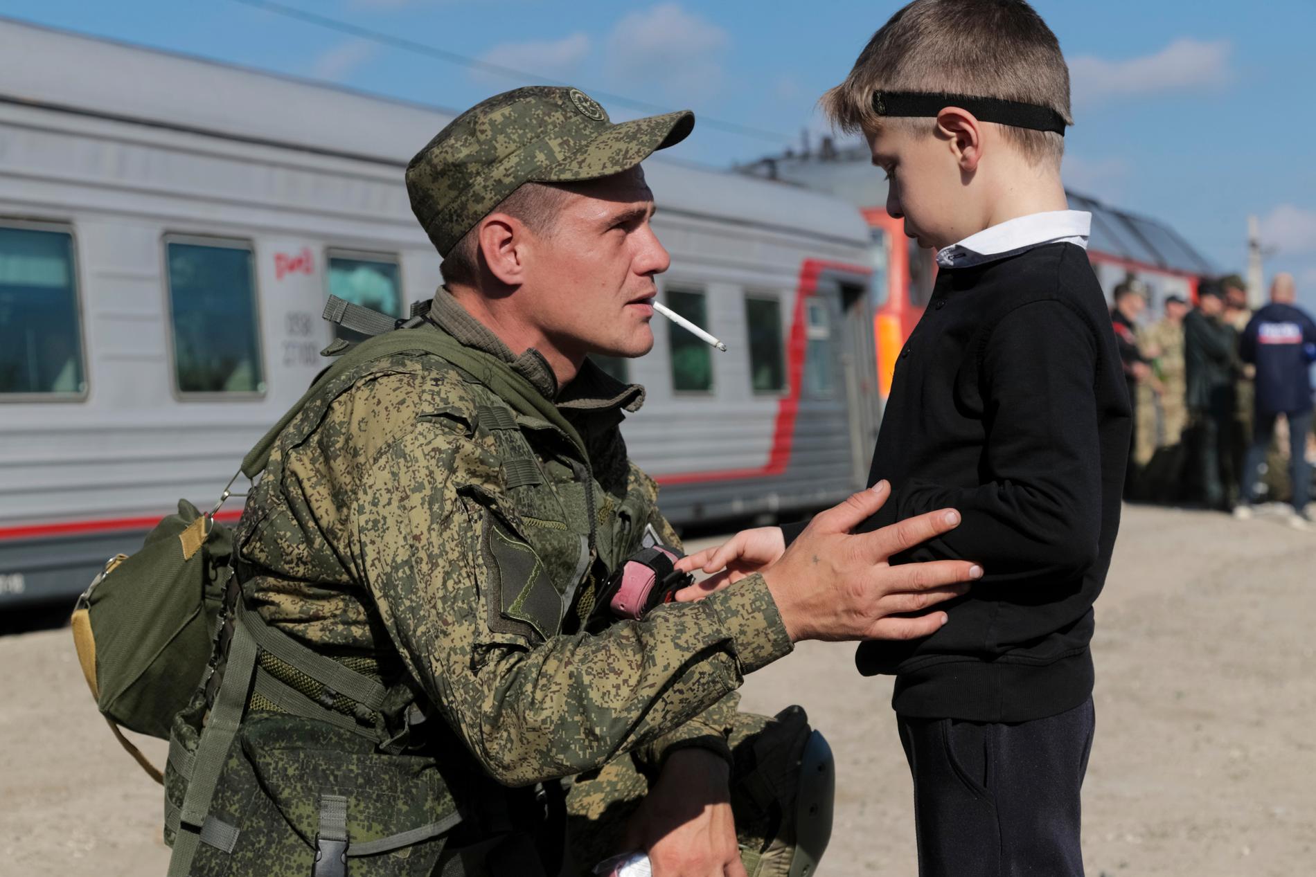 En rysk rekryt tar avsked av sin son innan han hoppar på ett tåg i regionen Volgograd på torsdagen.