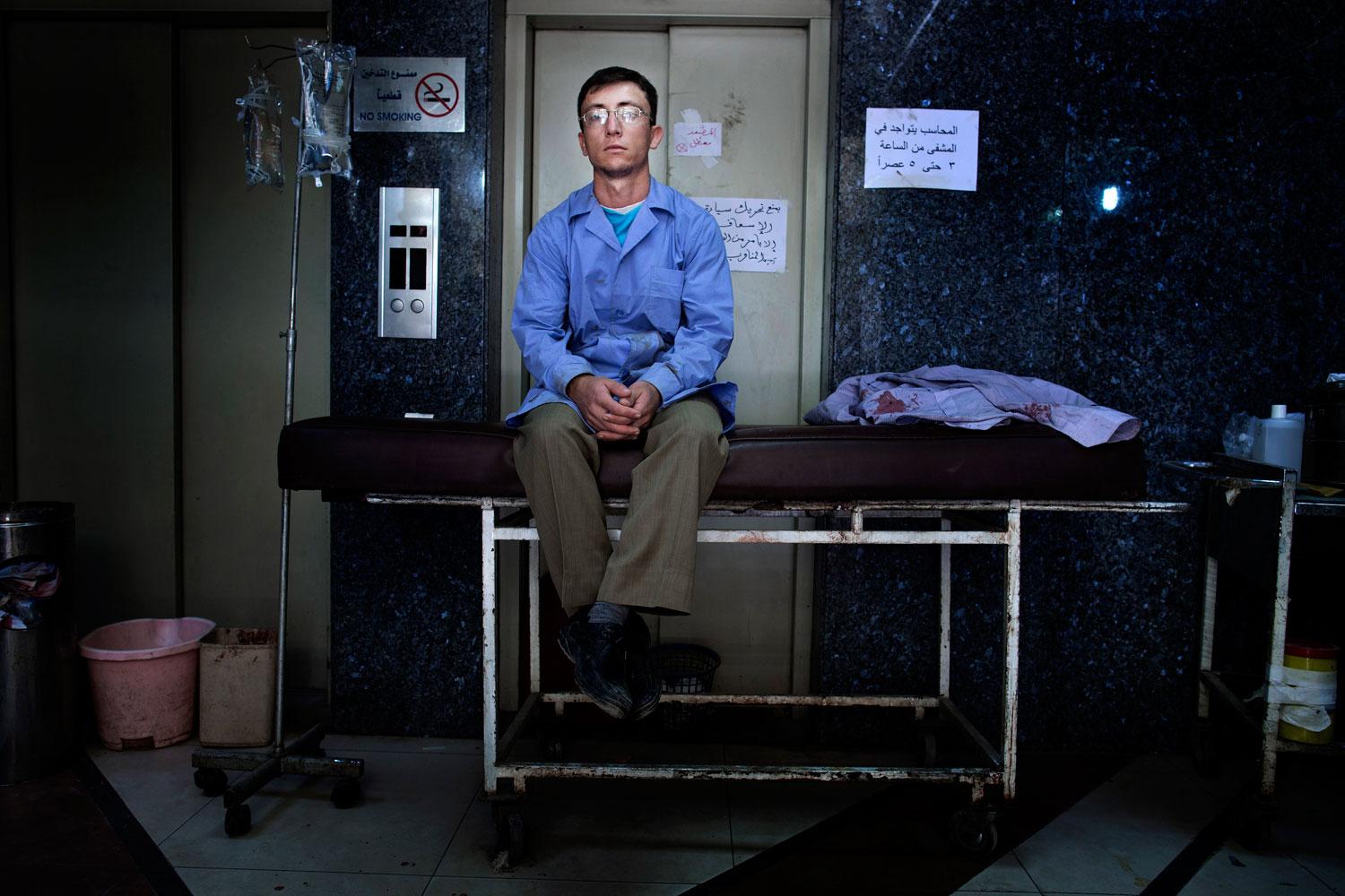 En man i sjukhuspersonalen tar en paus. Patienterna strömmar in till sjukhuset dag och natt, utan uppehåll.