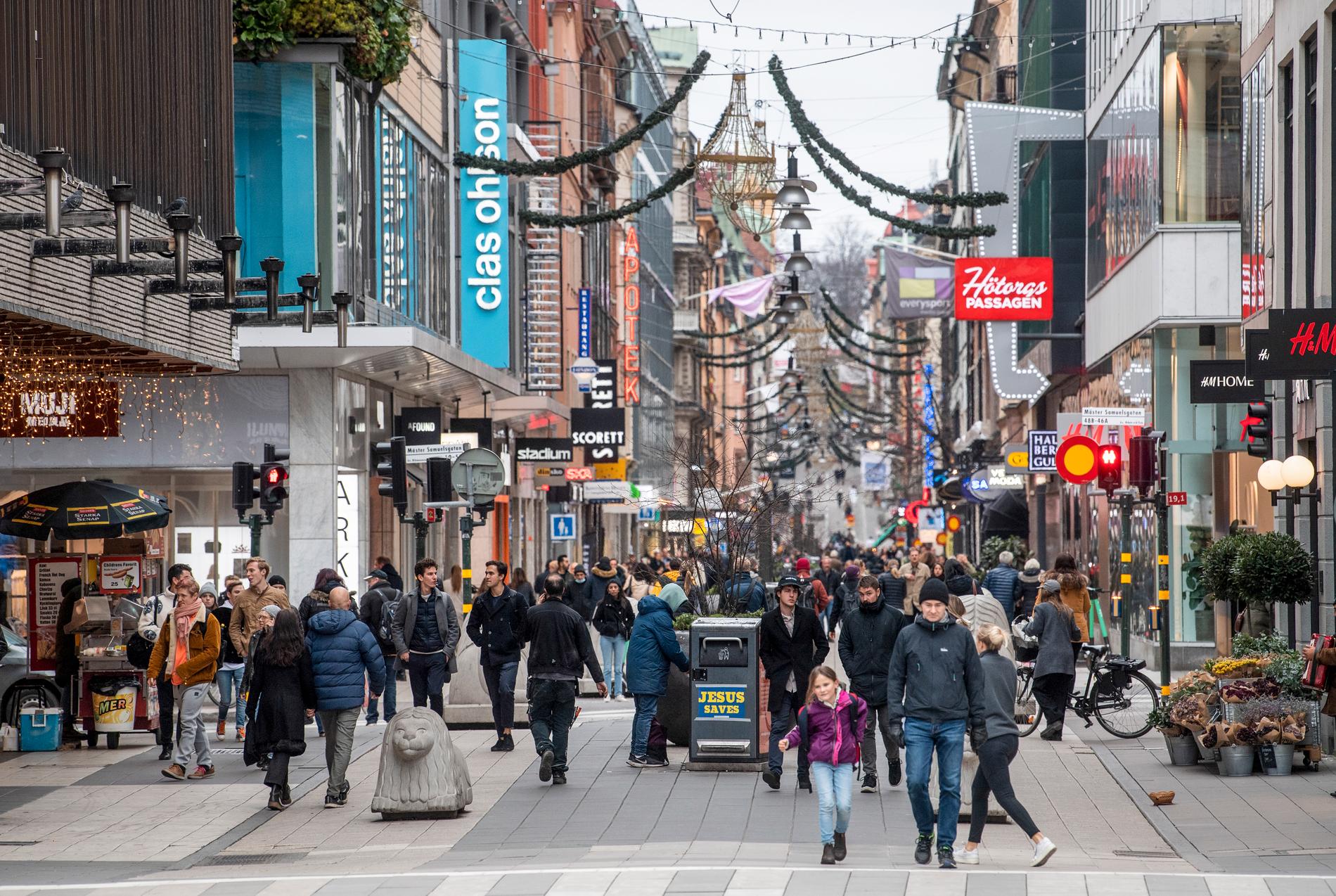 Människor promenerar på shoppingstråket på Drottninggatan i Stockholm.