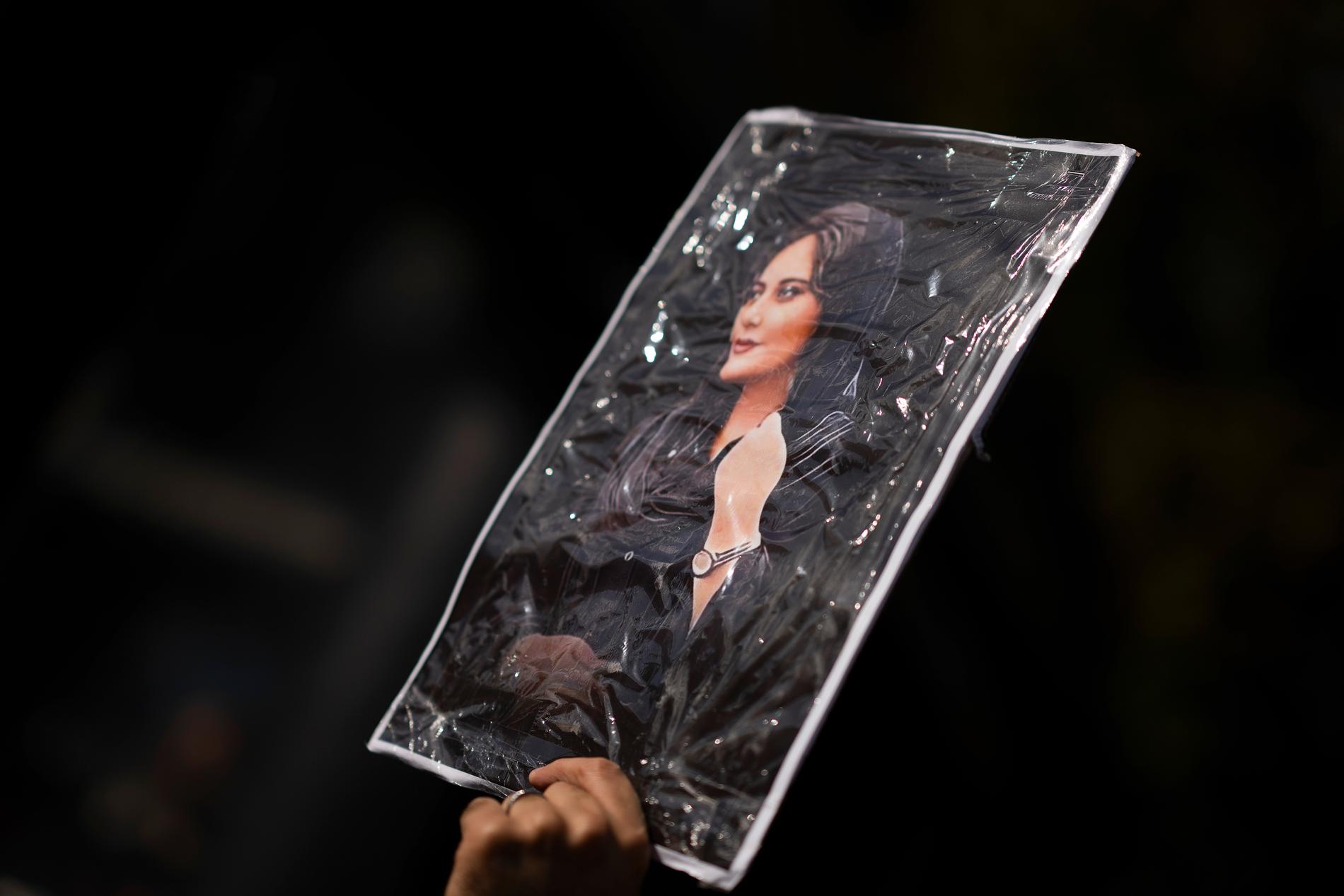 En demonstrant i Nederländerna håller ett porträtt av Mahsa Amini, 22, som dog i polisens förvar i Iran. Omfattande protester pågår i landet sedan dess. Arkivbild.