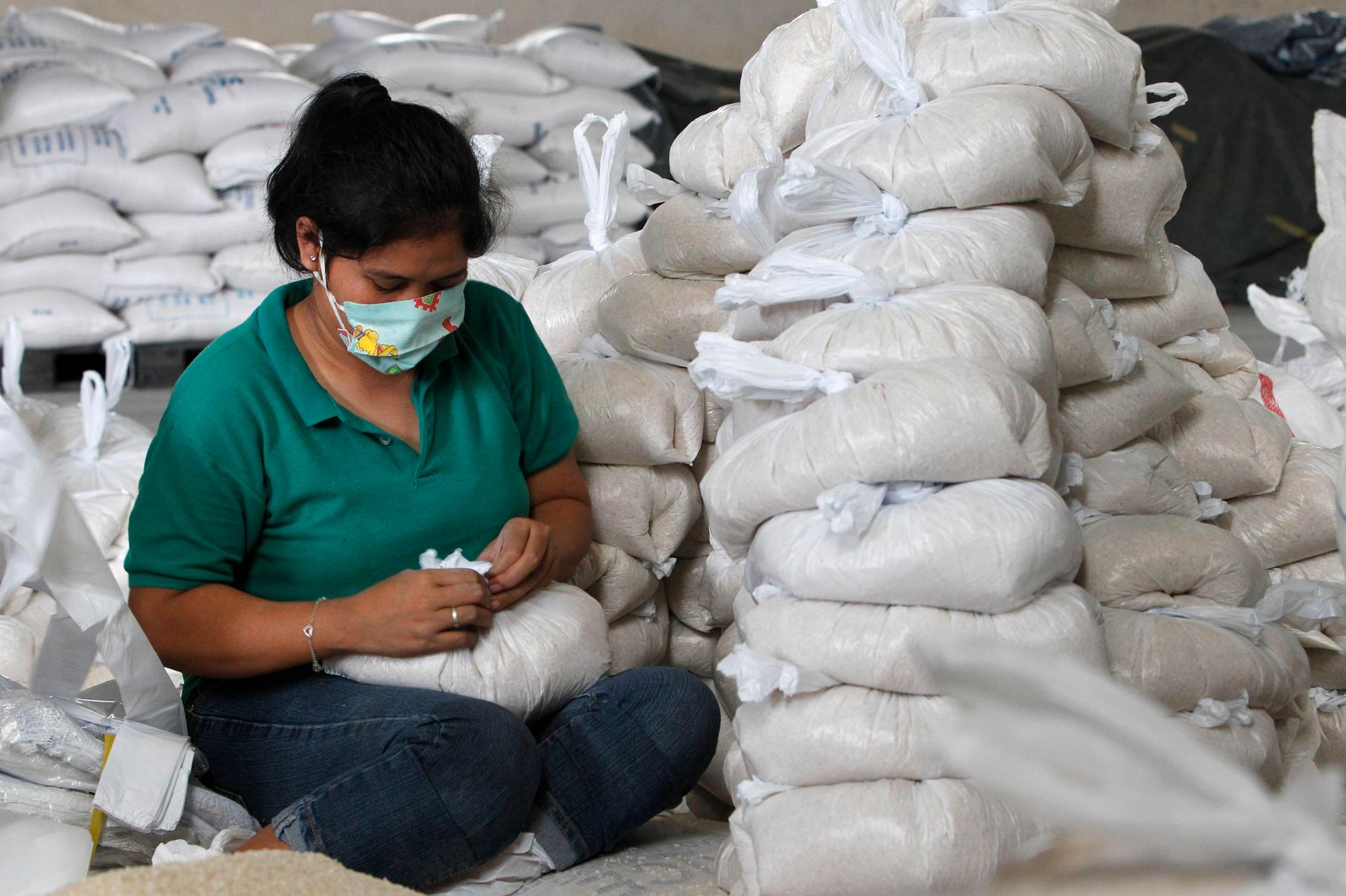 En hjälparbetare i Manila packar säckar med ris som ska skickas till drabbade områden.