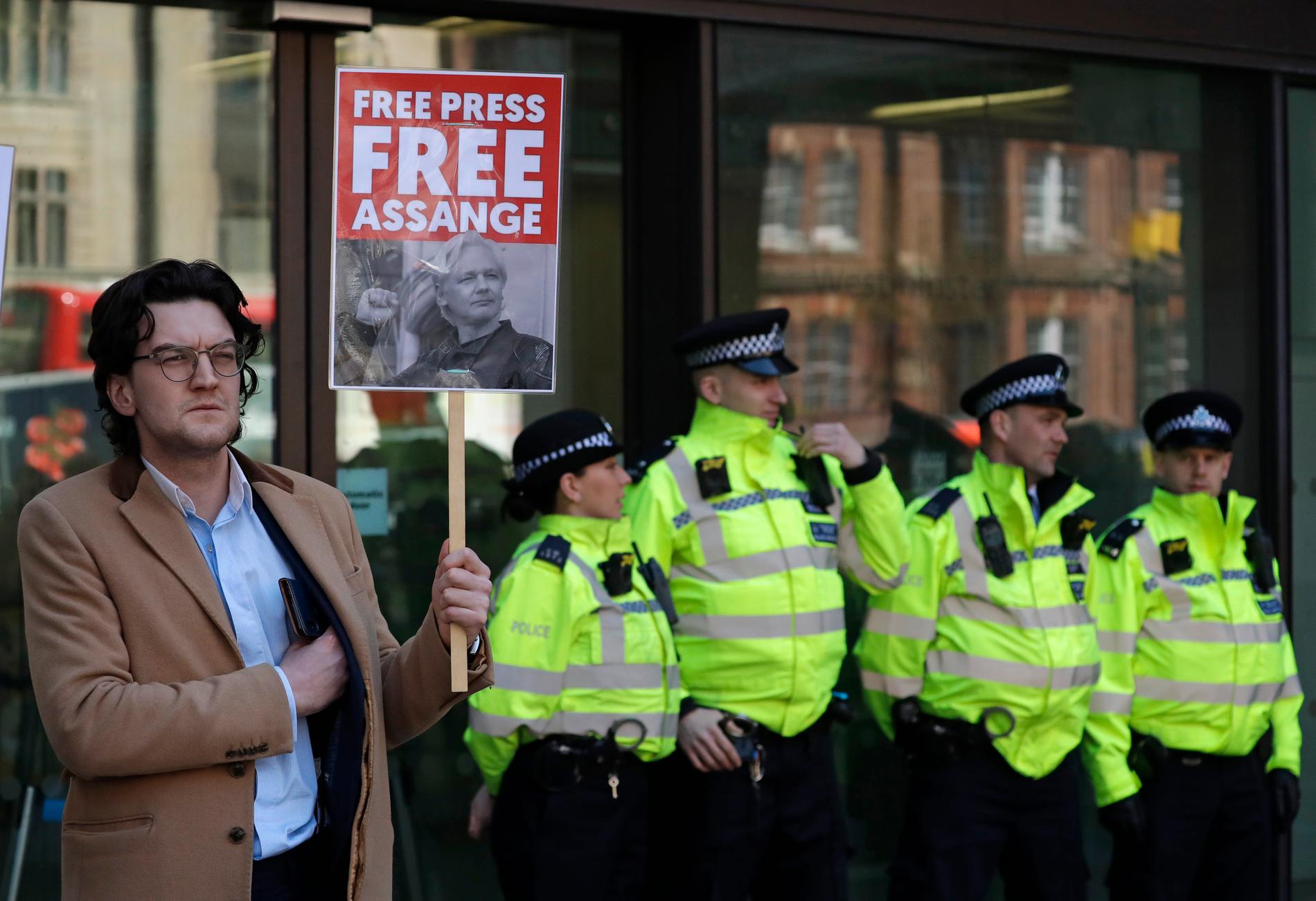 En demonstrant visar sitt stöd för Julian Assange utanför domstolen i London efter torsdagens gripande.