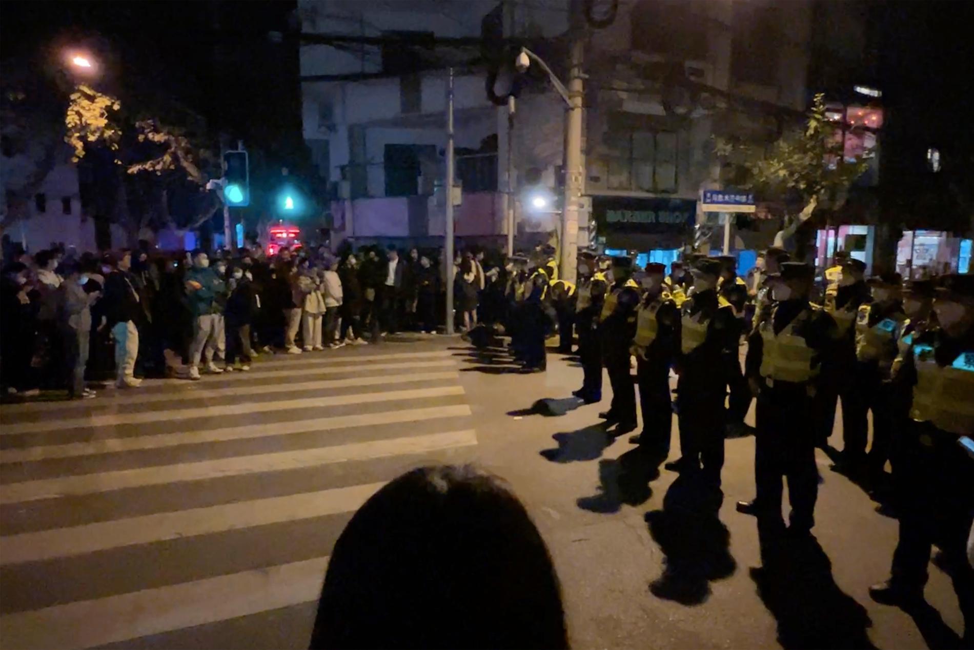 Polis och demonstranter i Shanghai under söndagen.