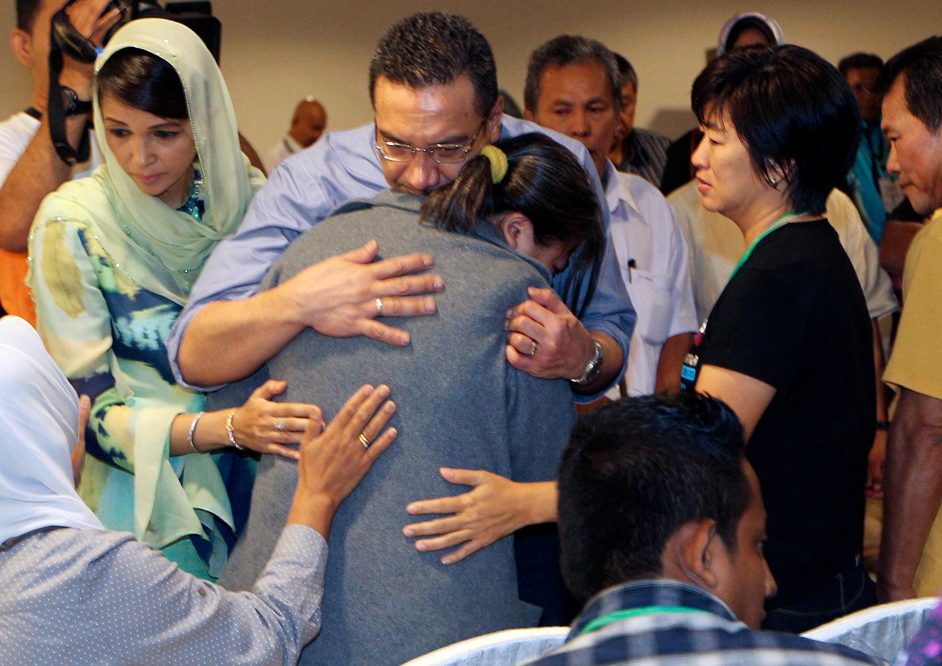 Malaysias transportminister tröstar en anhörig till en passagerare på MH370, efter att planet försvann.