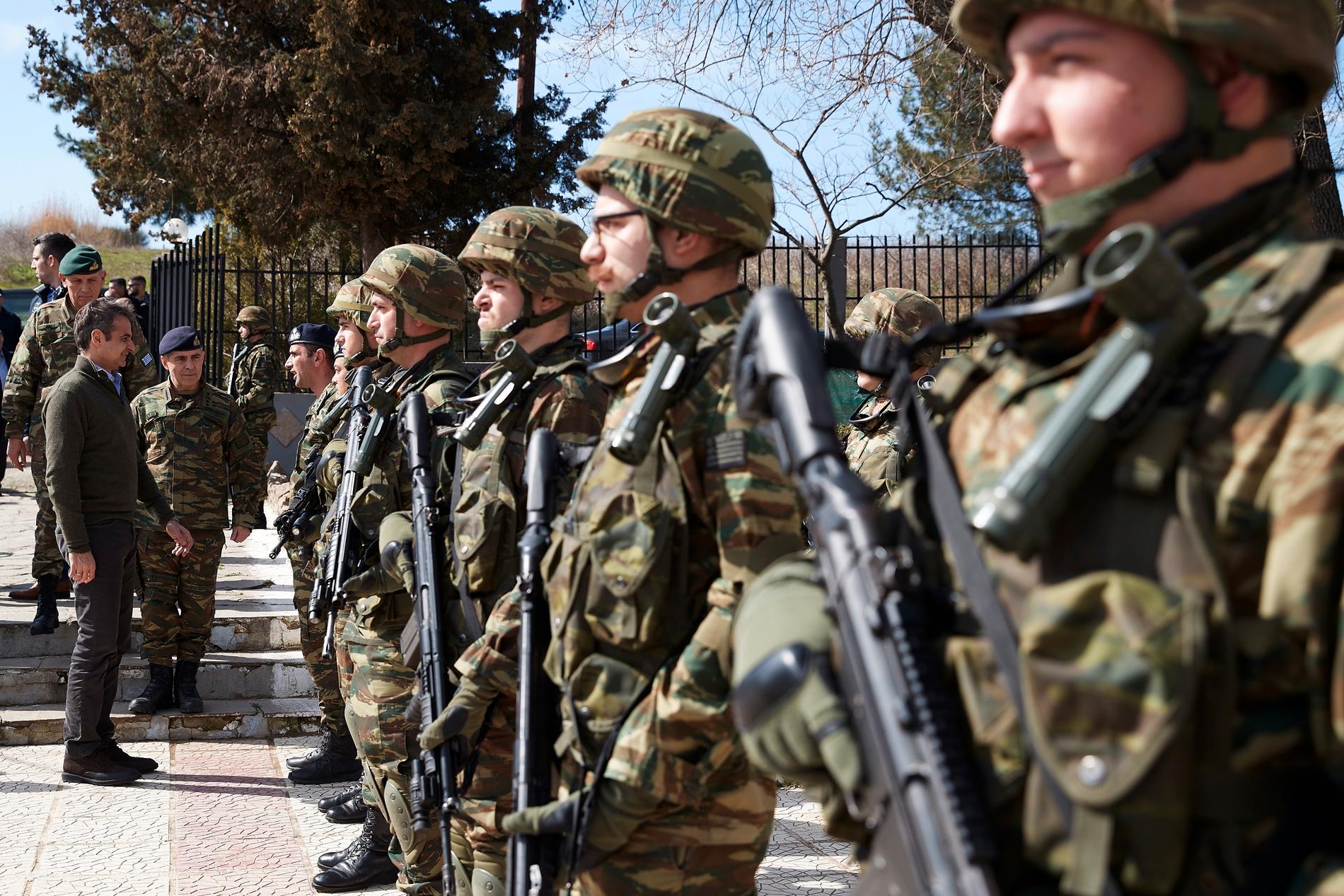 Greklands premiärminister Kyriakos Mitsotakis (till vänster) inspekterar grekiska soldater nära gränsen mot Turkiet.
