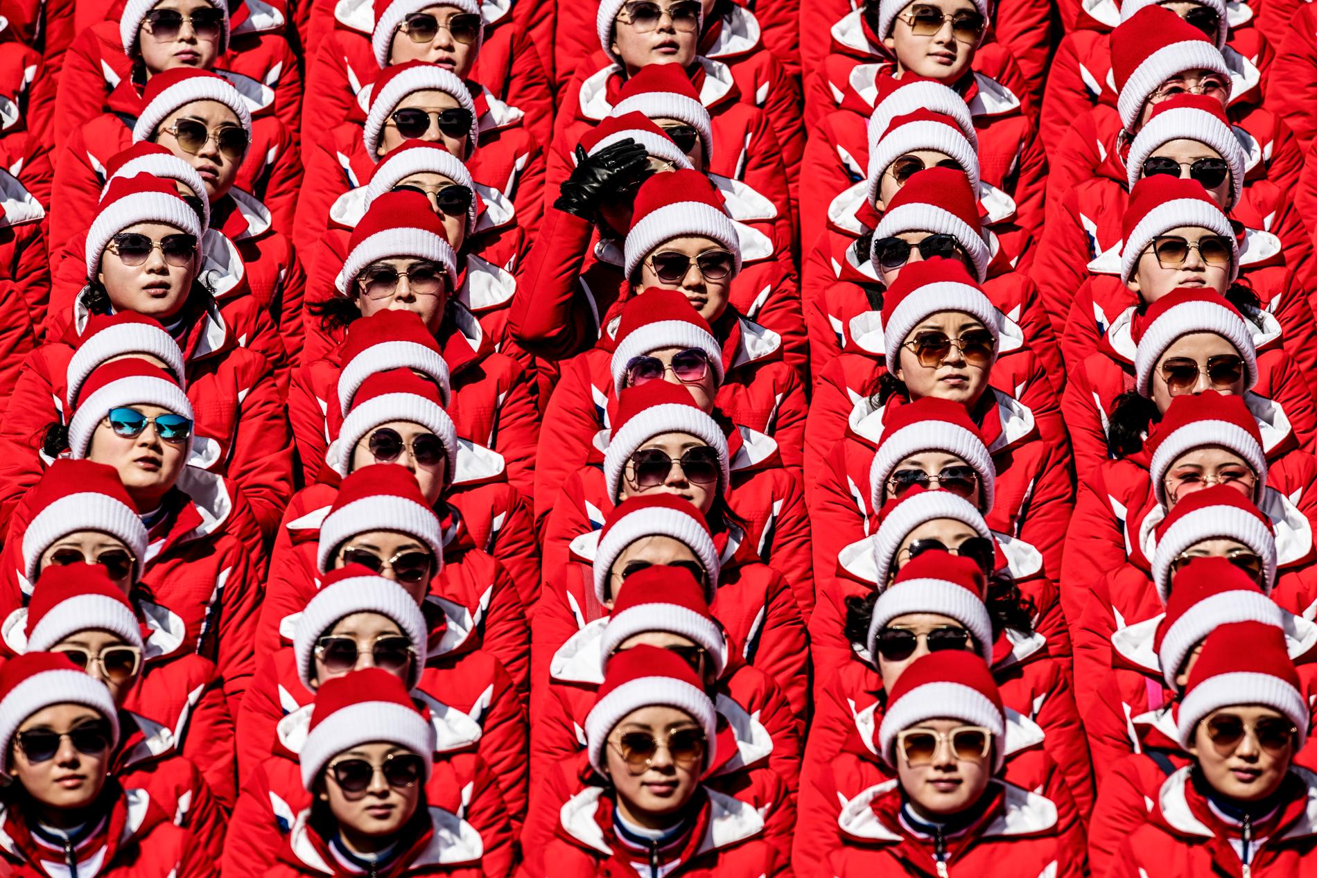 Med solglasögon av märken som Fendi och Dior är ”Skönhetens armé” på OS-läktaren. Nordkoreas ledare, Kim Jong-Un, har skickat den 230 personer stora hejarklacken till Sydkorea. Klackmedlemmarna är utvalda utifrån längd och familjebakgrund. Cirka 60 kvinnor är på Yongpyong Alpine Centre för att heja fram den nordkoreanska slalomåkaren Myong Gwang Choe, som slutar sist den 22 februari 2018. 