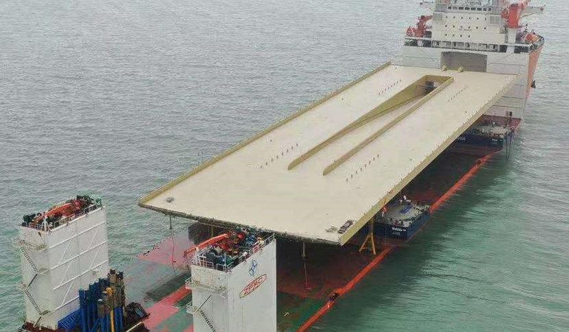Fartygets speciella konstruktion gör det känsligt för vågor, men gör också att det kan transportera den 140 meter långa bron.