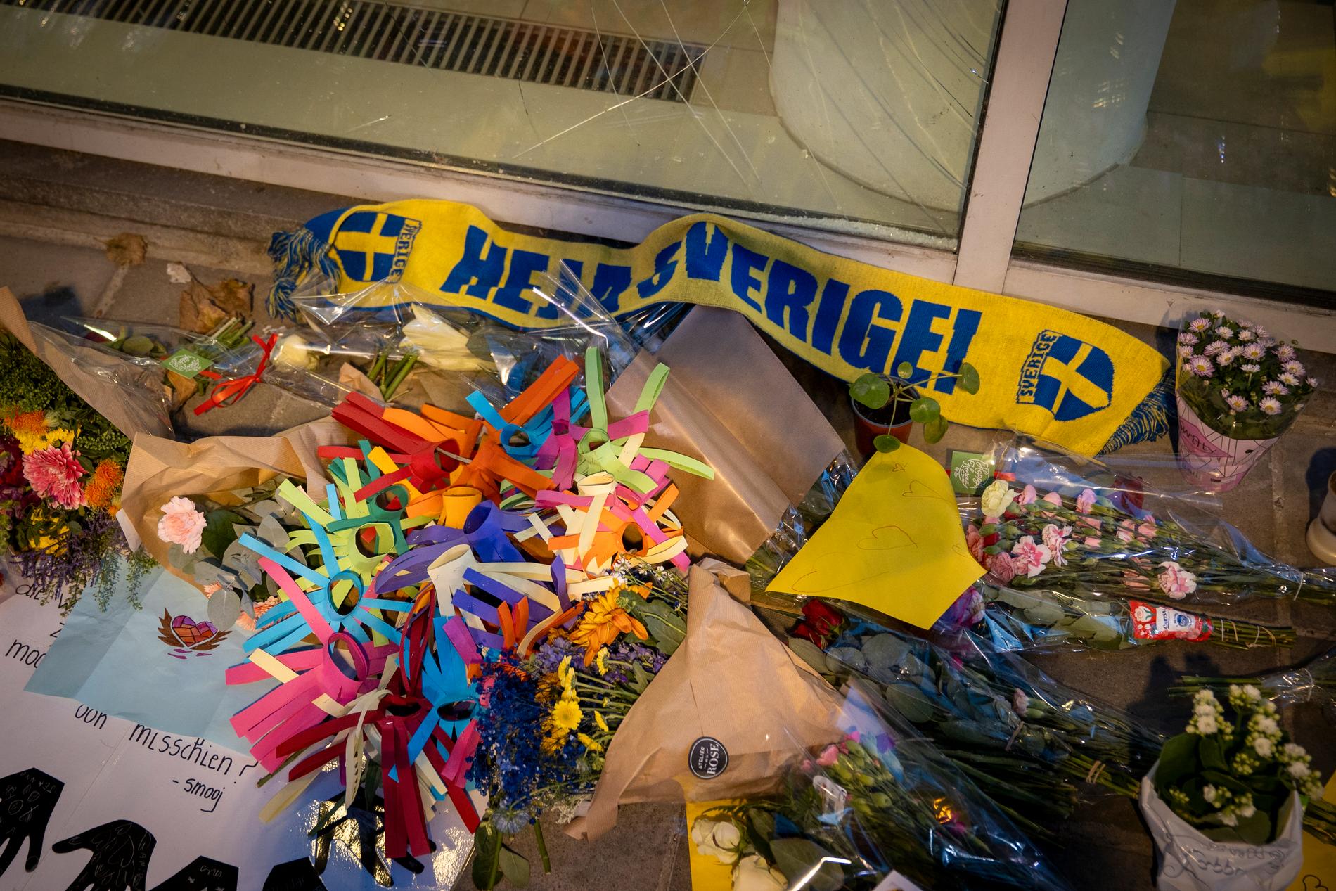 Sverigehalsduk och blommor vid en minnesplats i Bryssel.