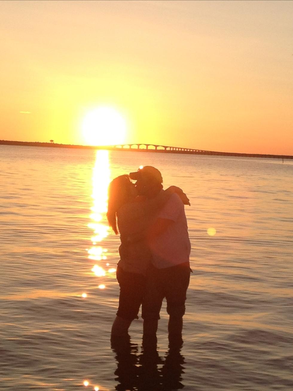 Kärlek i solnedgången med Ölandsbron i bakgrunden.