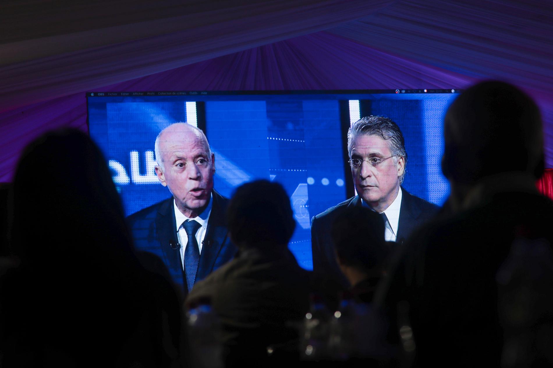 Tunisier tittar på en tv-sänd debatt mellan presidentkandidaterna Kais Saied och Nabil Karoui tidigare i veckan.
