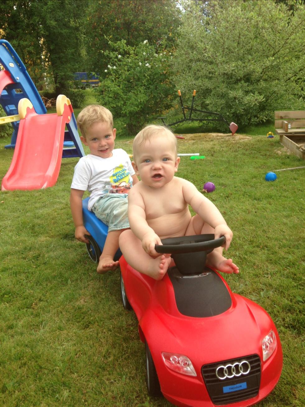 Theodor och Gabriel tar sig en biltur i trädgården.