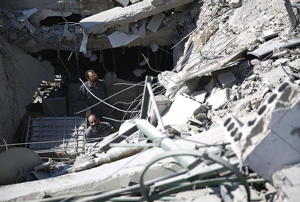 Räddningsarbetare söker igenom rasmassor i Douma, Syrien.