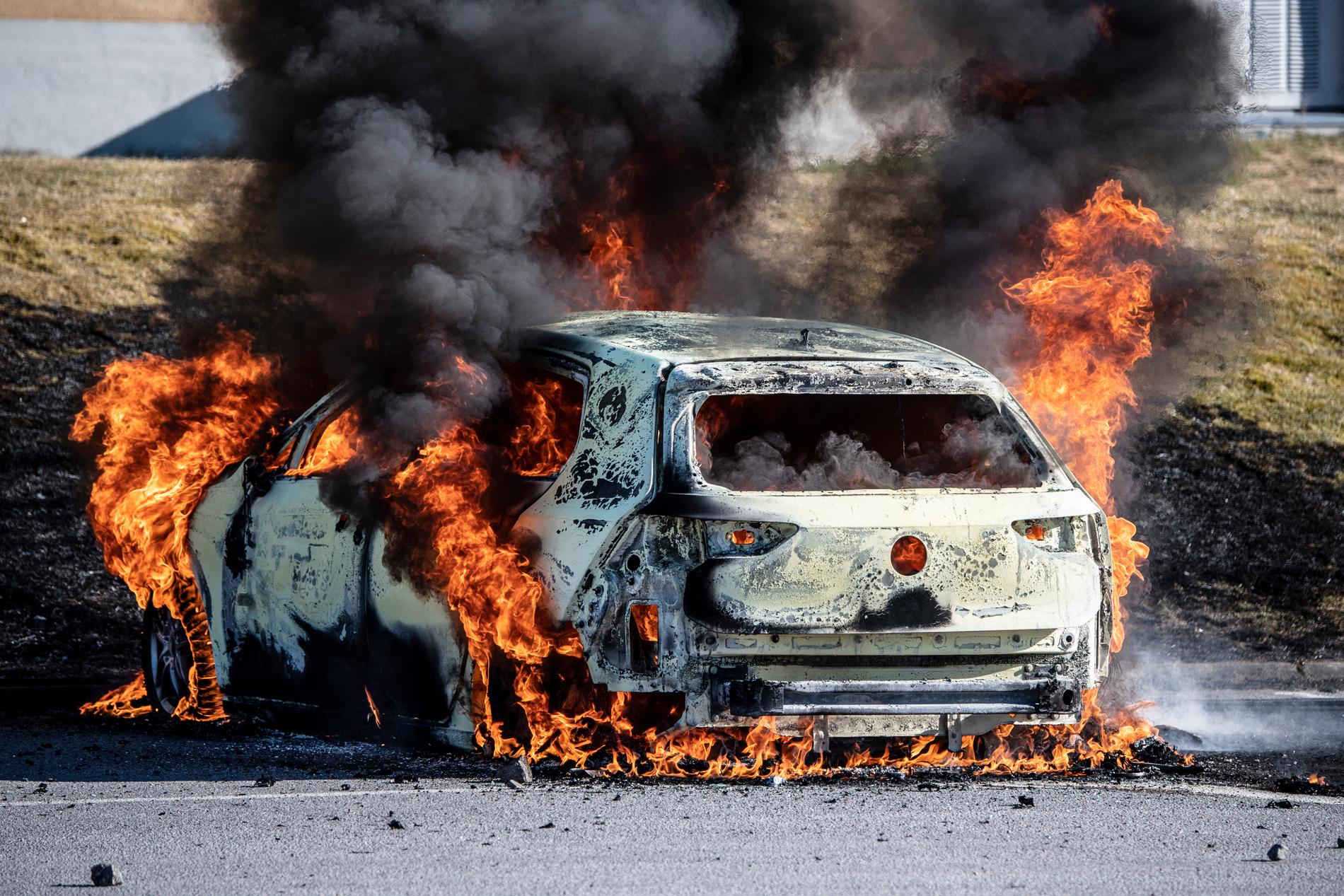 En brinnande bil efter upploppen i Norrköping.