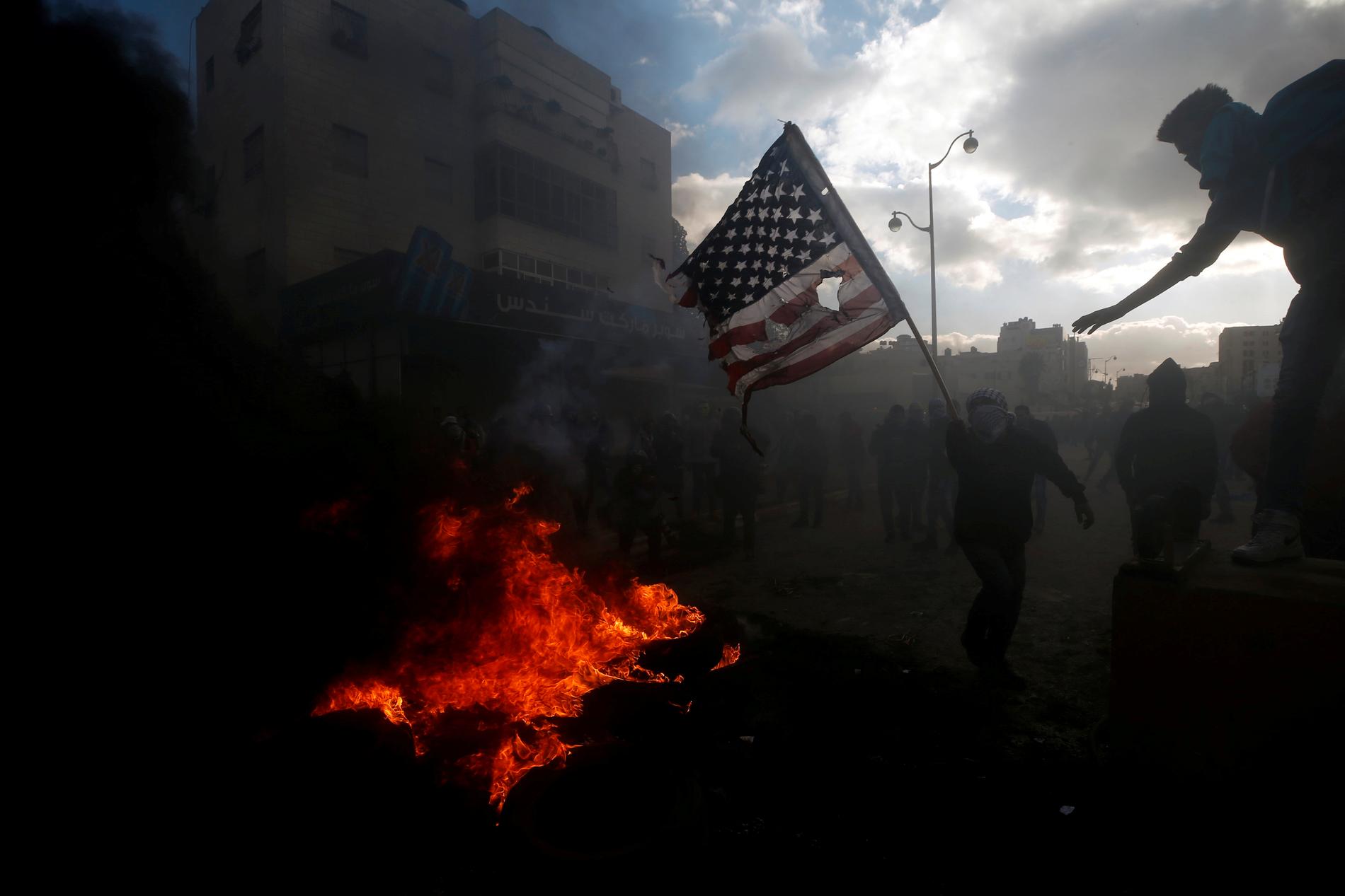 En demonstrant bränner en amerikansk flagga i Ramallah, Västbanken