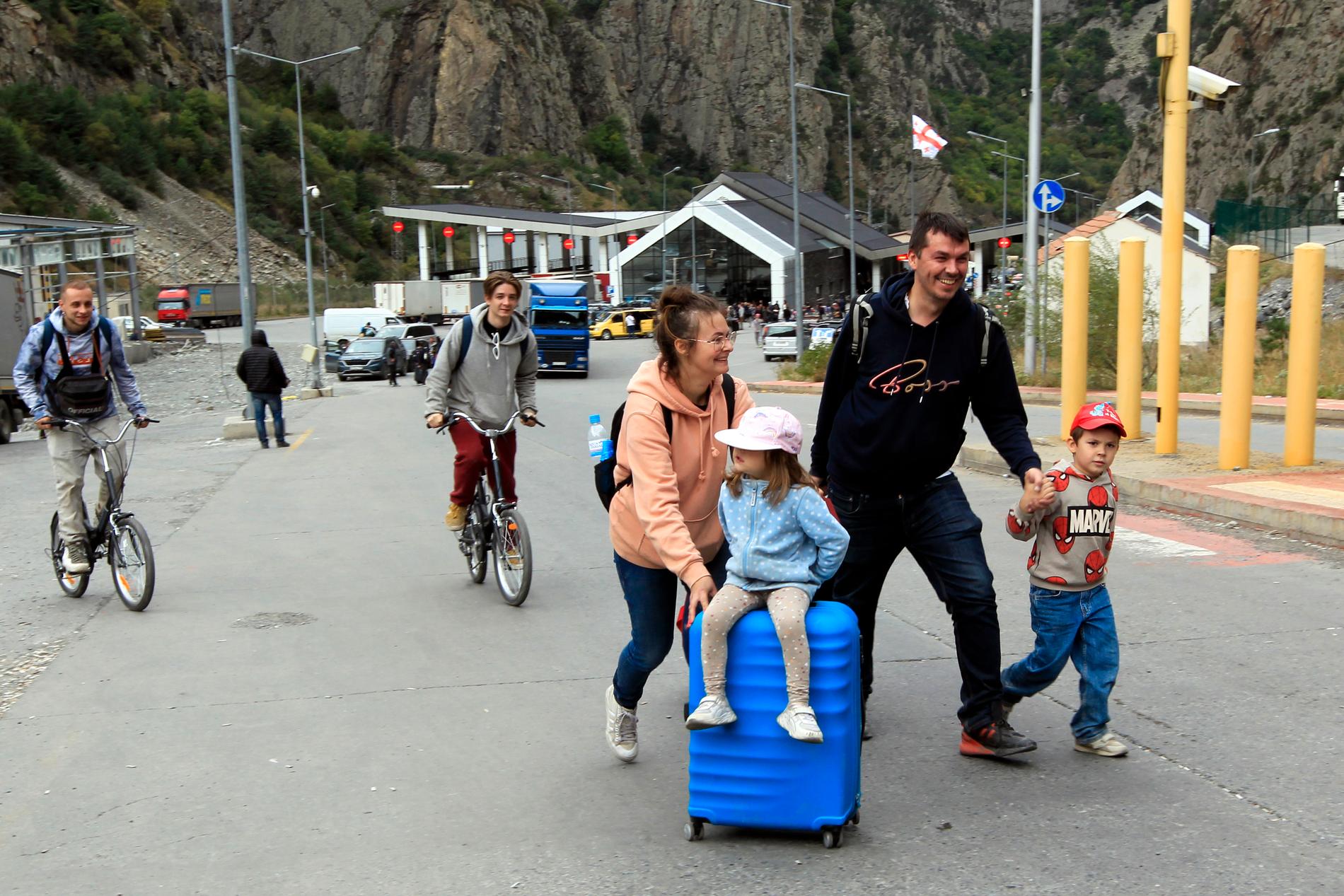 En ung familj och två cyklister korsar den ryska gränsen, kallad Verkhnii Lars, för att ta sig till Georgien.