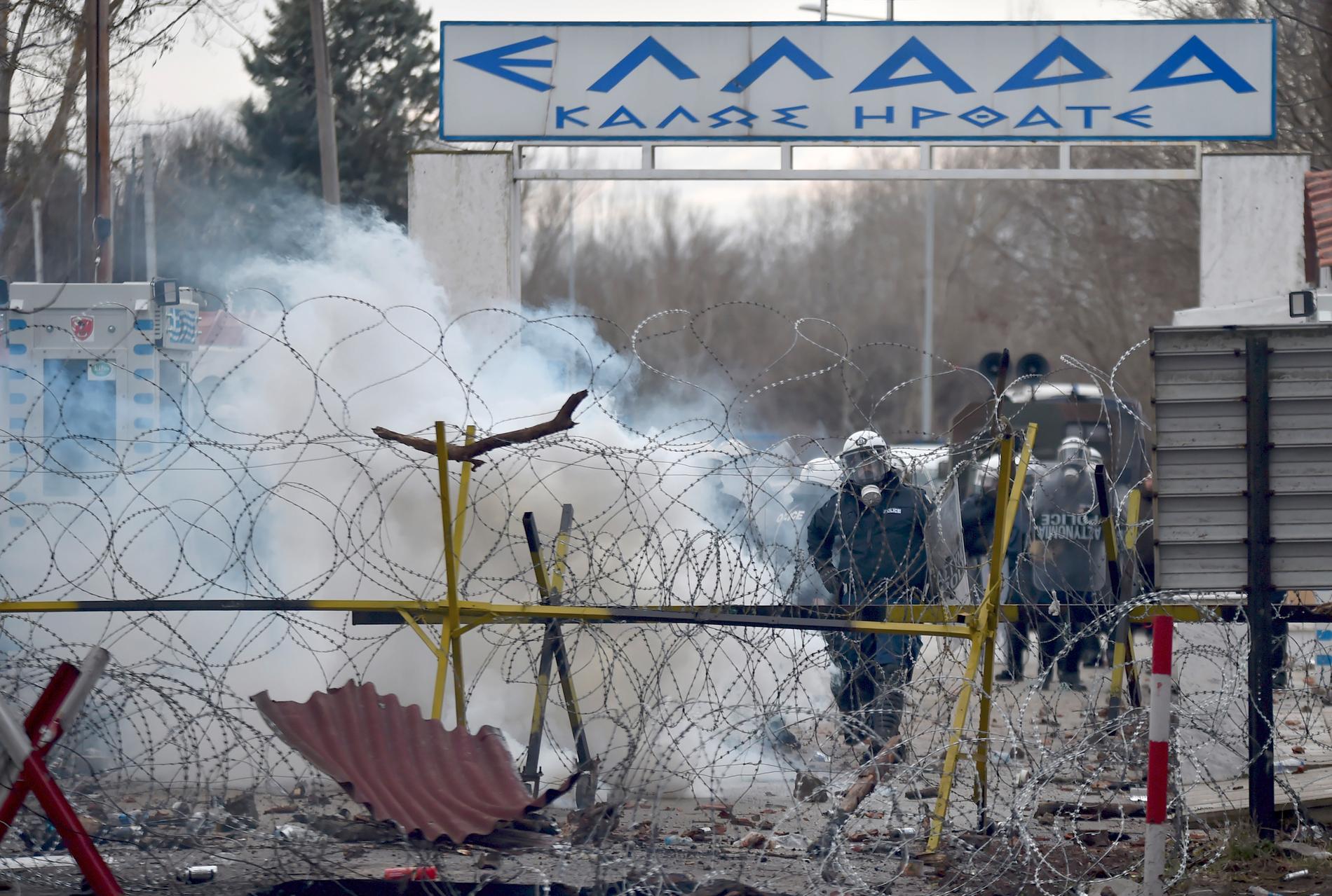 Grekisk gränspolis försöker hålla tillbaka migranter som försöker ta sig in i Grekland med tårgas.