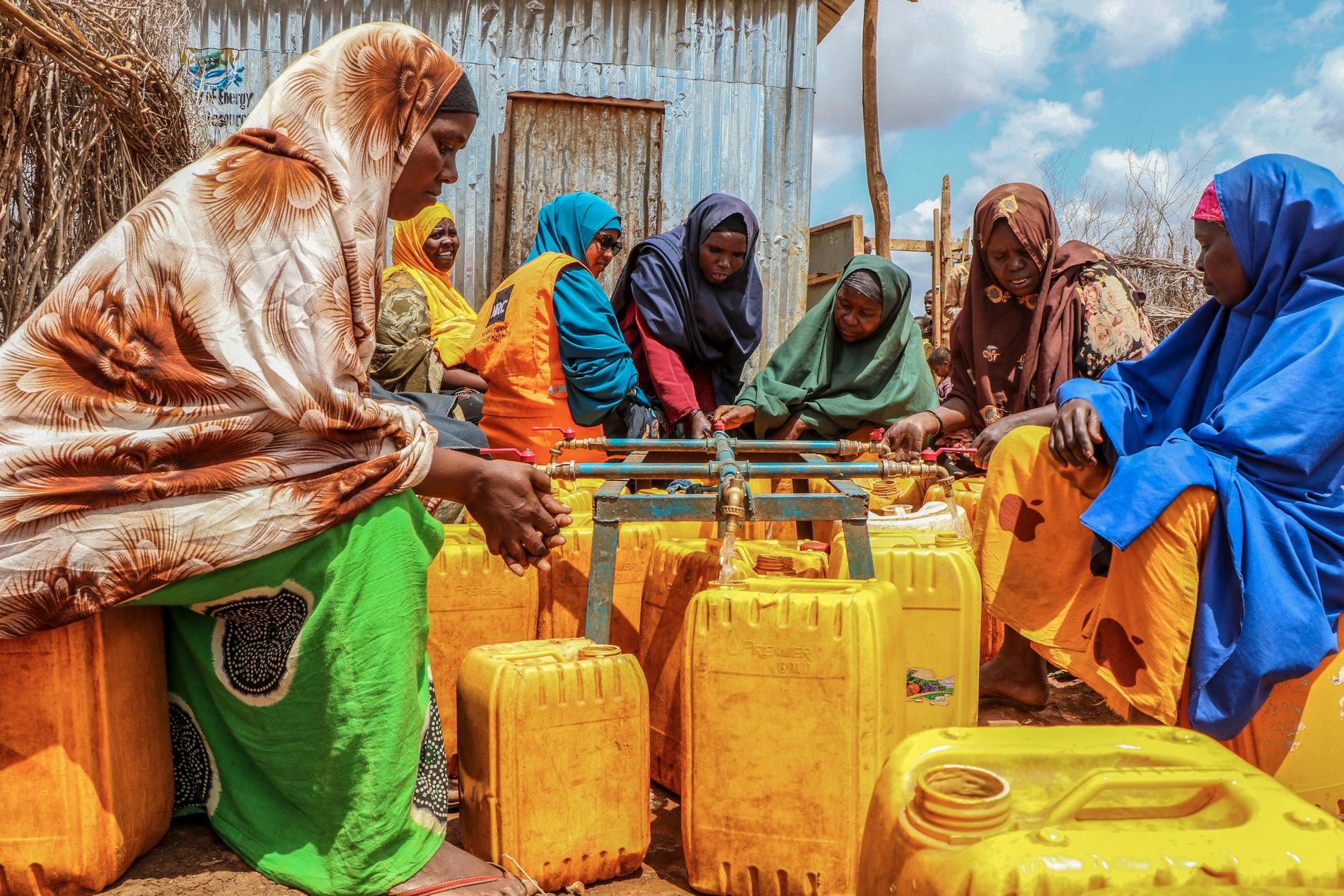 Hundratusentals somalier har tvingats lämna sina hem på grund av den svåra torkan. På bilden syns kvinnor i ett läger för internflyktingar som fyller på sina vattendunkar tidigare i juni.