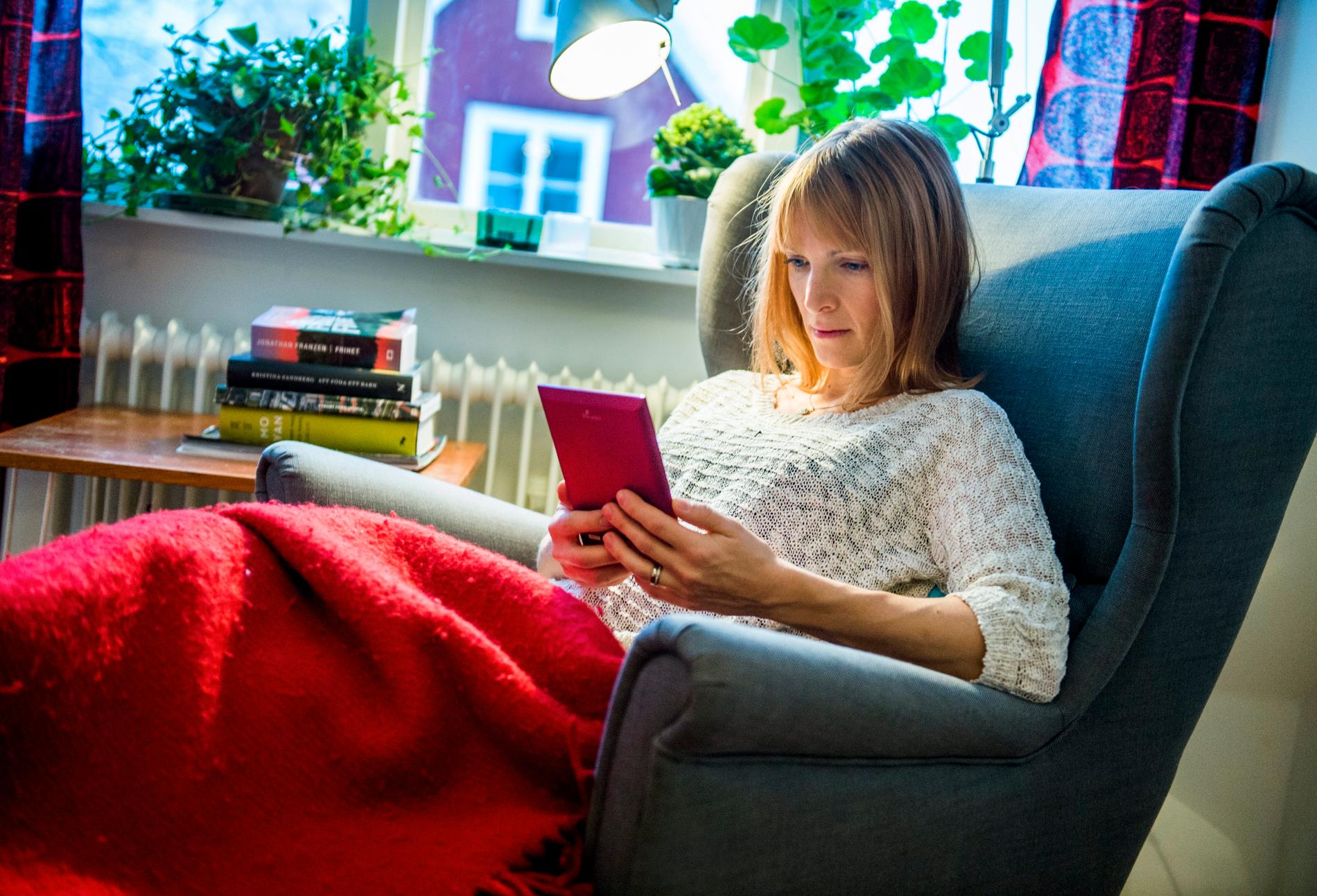 En kvinna läser en bok på en läsplatta.