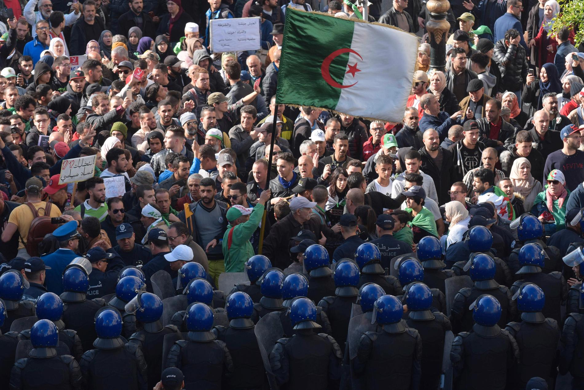 Säkerhetsstyrkor på rad framför demonstranter i Algeriets huvudstad Alger under protester på onsdagen.