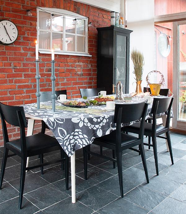 Matplatsen i köket är placerad vid stalldelens tegelvägg. Bord samt stolar är ritade av Stina Sandwall och kommer från Lundbergs möbler i Tibro. 