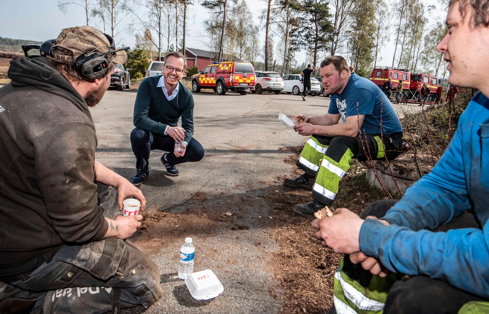 Inrikesminister Mikael Damberg samtalar med Peter Svensson, Johan Svensson och Robin Persson, som hjälper till med skogsbrandsläckningen utanför Hästveda.