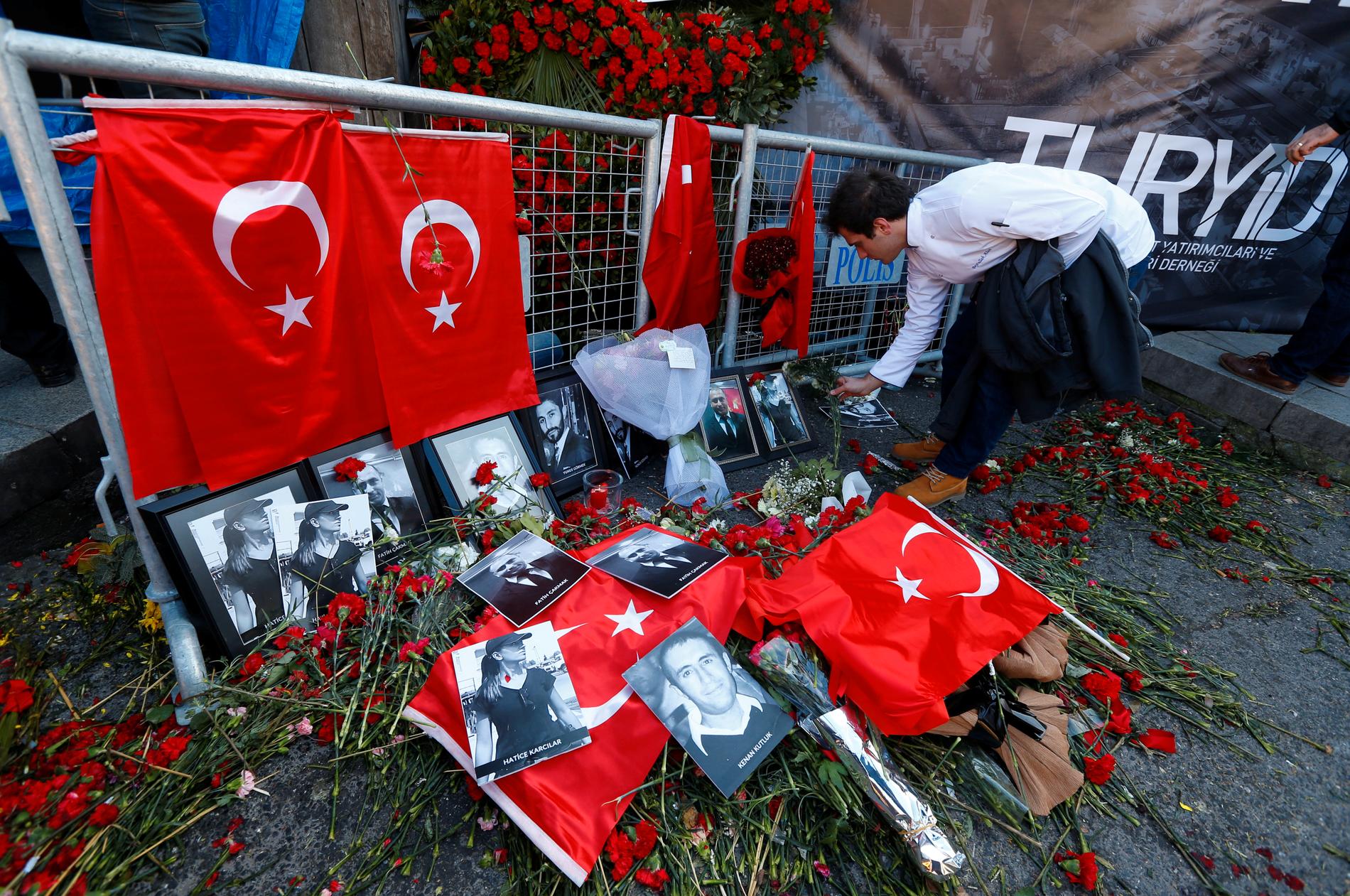 En person lägger blommor utanför nattklubben Reina i Istanbul där 39 personer sköts ihjäl.