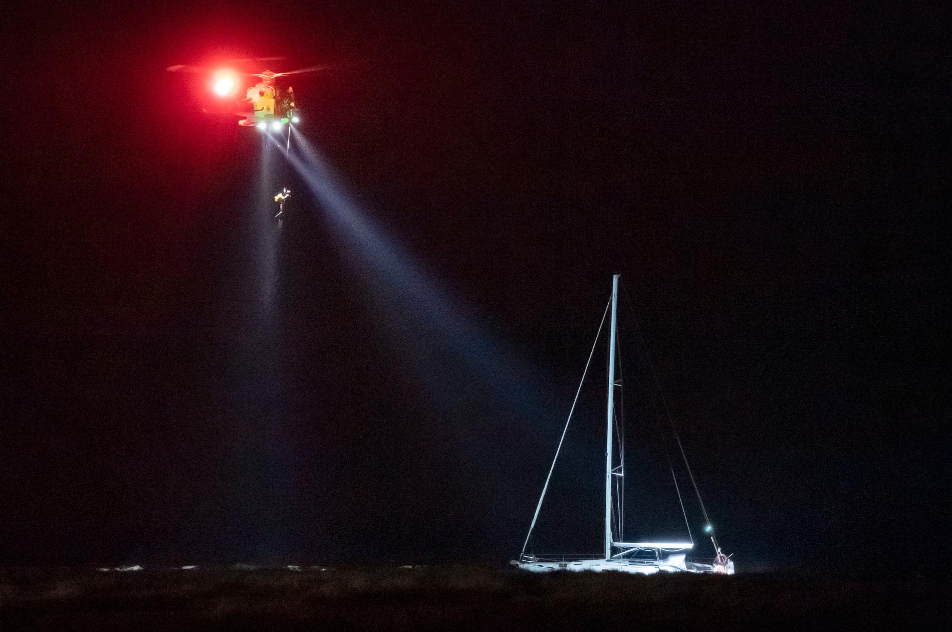 Sjöräddningens helikopter vinschar upp en person vid den grundstötta segelbåten vid Falsterbo fyr på tisdagskvällen. Arkivbild.