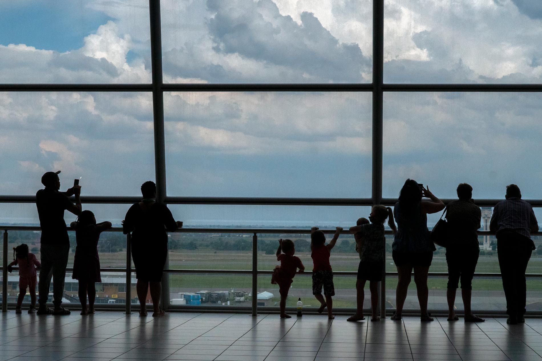 Familjer på Tambo-flygplatsen i Sydafrika, ett land som många länder nu stänger reseförbindelserna med av rädsla för att importera fler omikronfall.