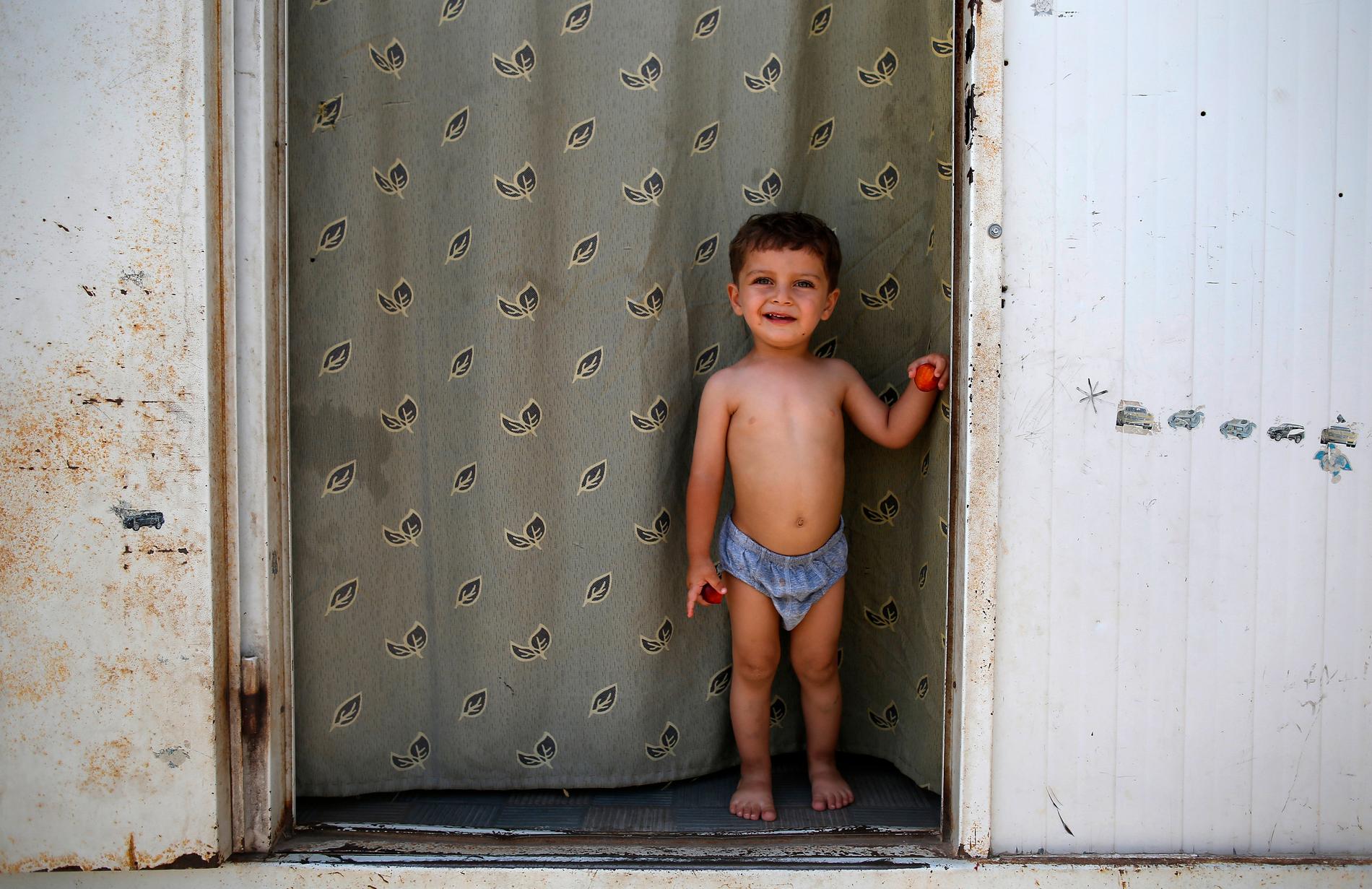 Inte välkommen Den syriske flyktingen Mustafa Mahmud, 2 år gammal, står i dörren till den container där hans familj numera bor. I staden Kilis på gränsen mellan Turkiet och Syrien.