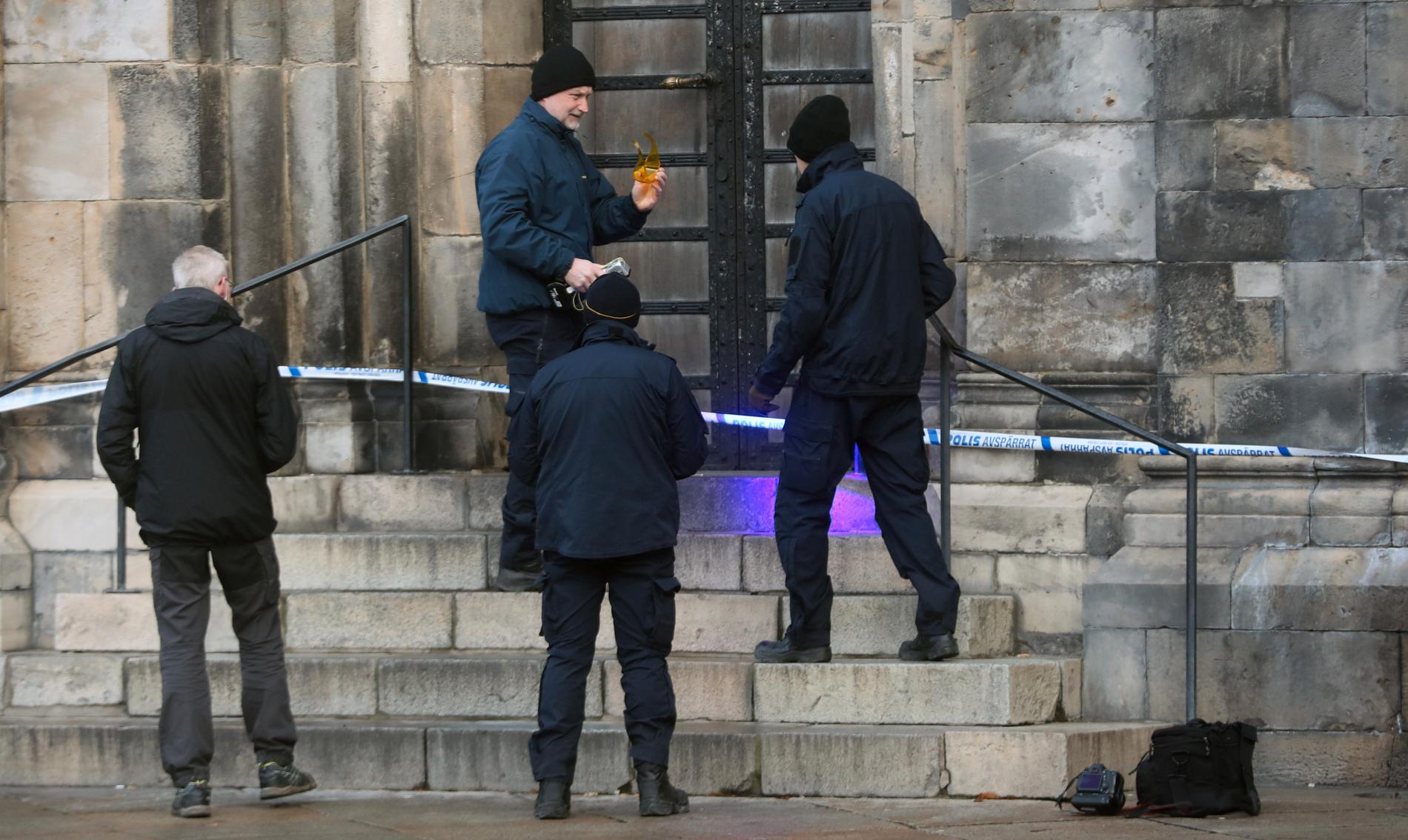 Polisens tekniker undersöker en trappa utanför domkyrkan i Lund där en kvinna ska ha våldtagits.