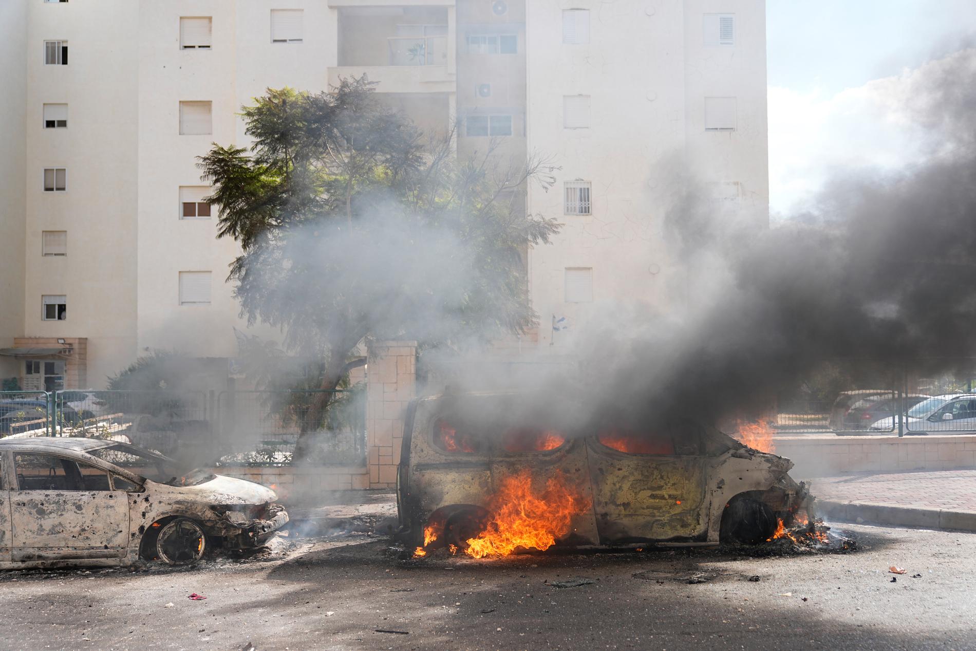 Brinnande bilar som träffats av raketer från Gaza, inne i Israel. 