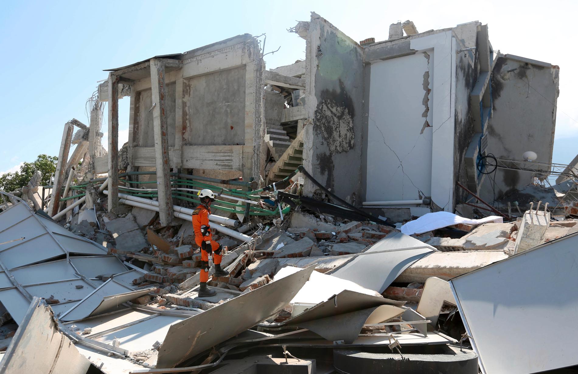 En räddningsarbetare inspekterar skadorna på Roa-roa hotell efter jordskalvet och tsunamin som drabbat Indonesien.