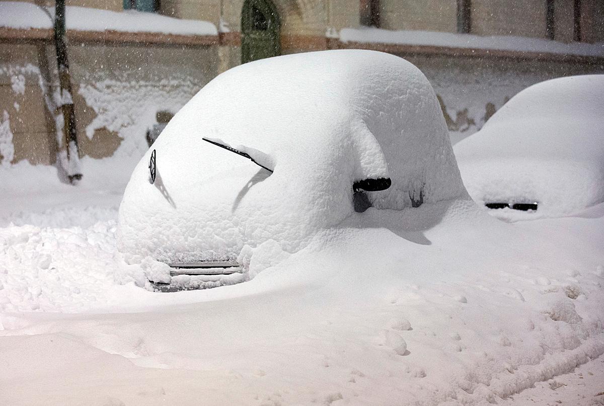 En bil helt täckt av snö efter senaste snöovädret i Stockholm.
