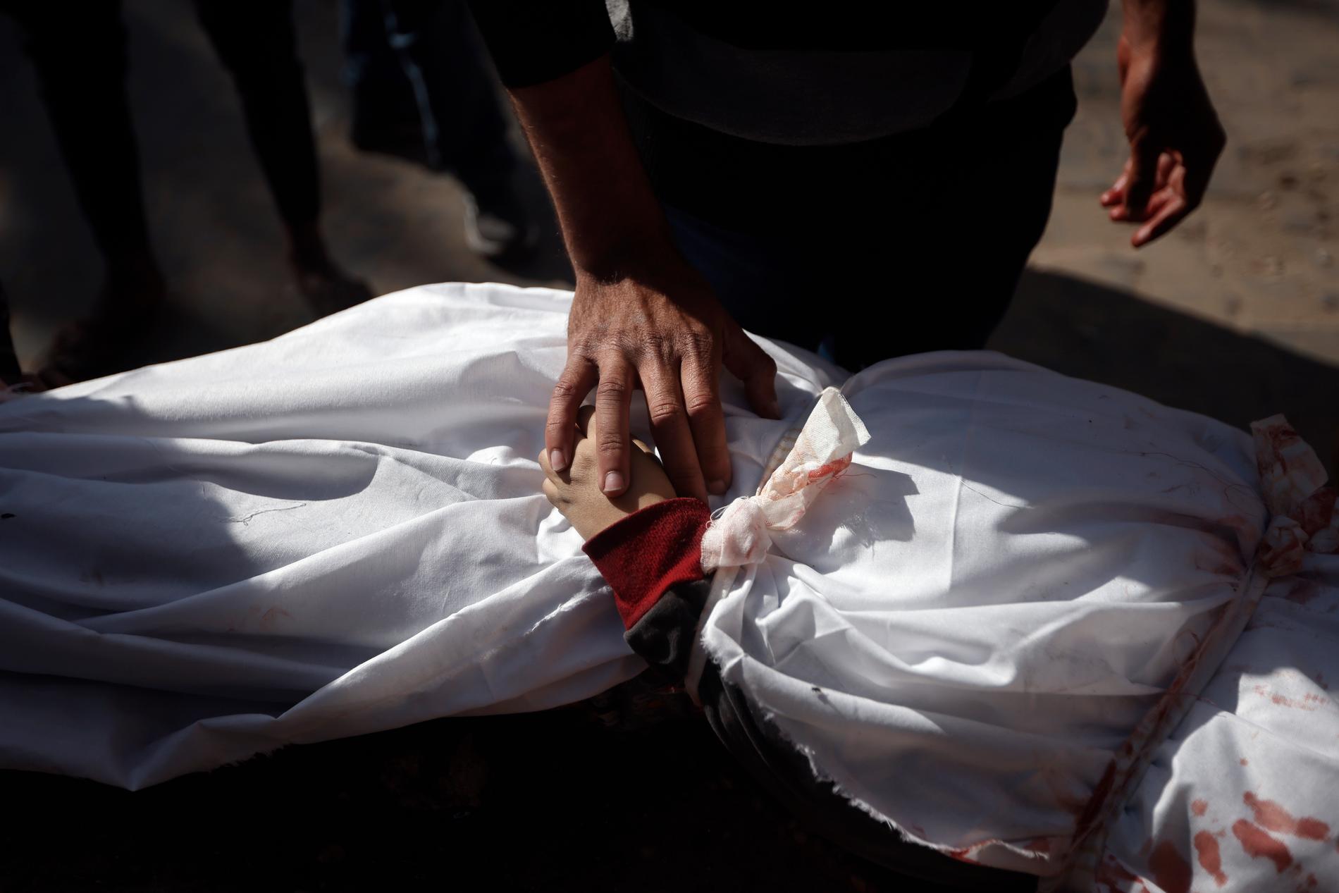 Ett barn som dödats i en israelisk attack insvept i ett lakan vid Nassersjukhuset i Khan Yunis. Bild från i januari.